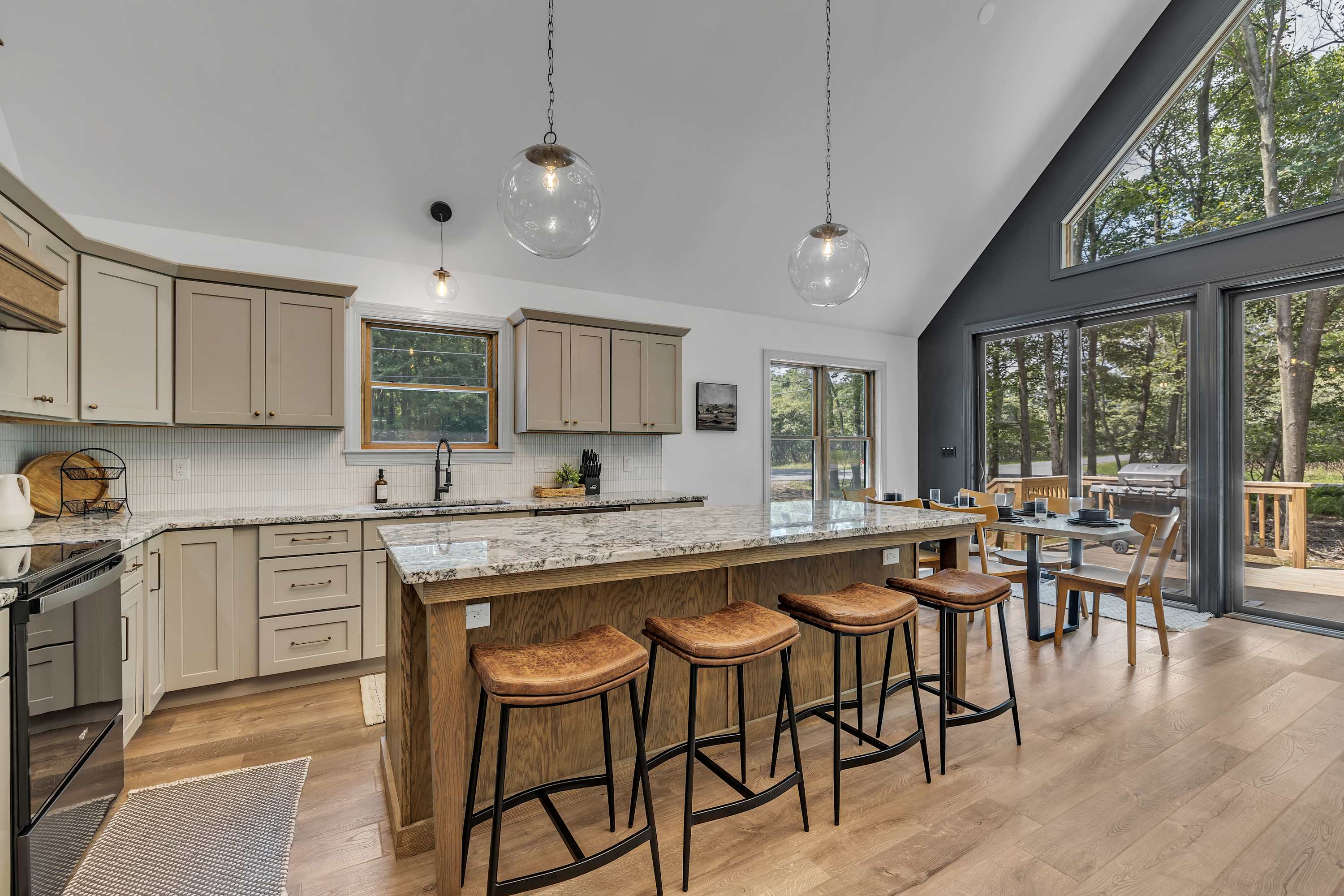 Gourmet Kitchen with a View – A spacious chef’s kitchen with high-end appliances, a large island with bar seating, and expansive windows that bring in nature.