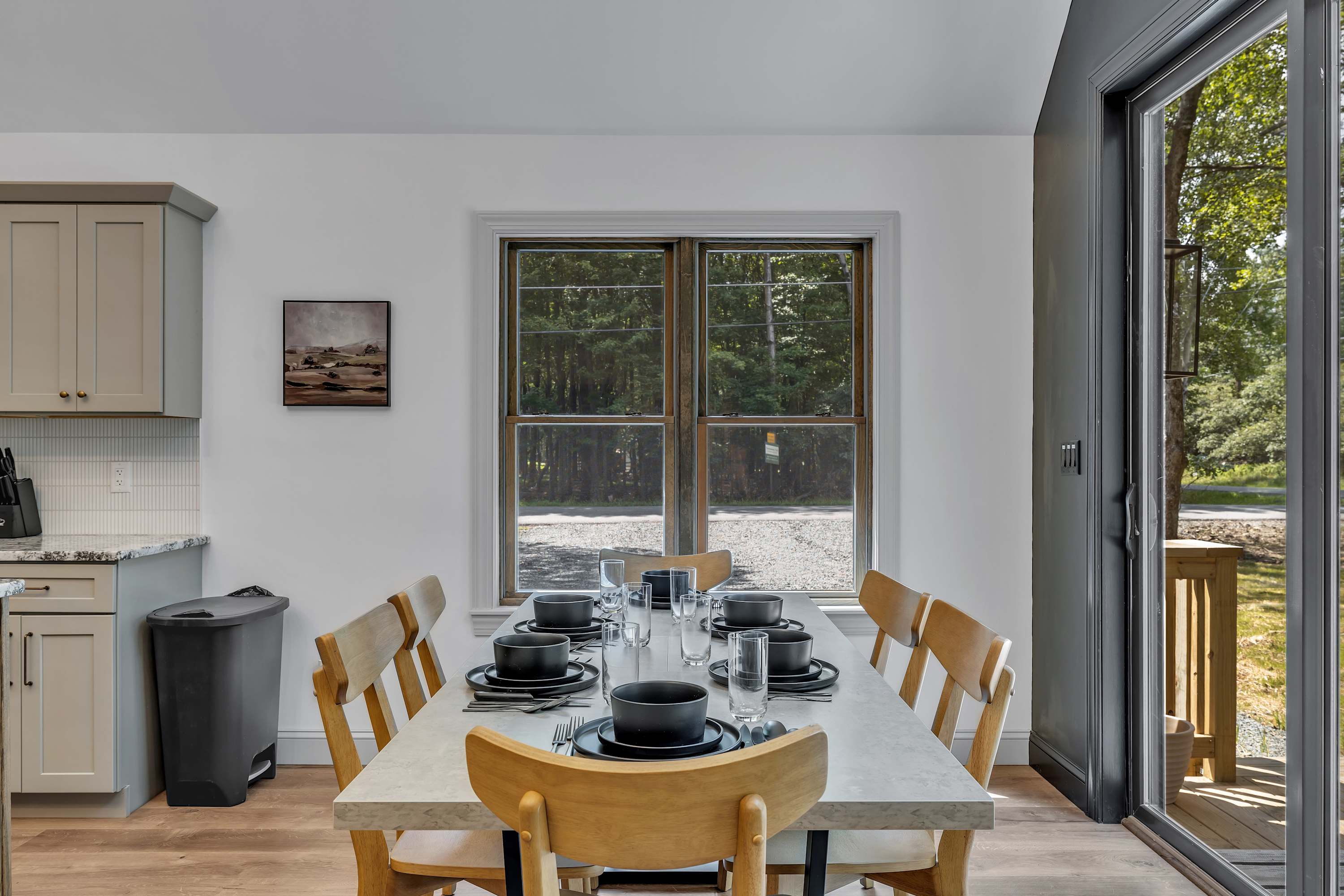 Cozy Dining with Natural Light – A beautifully set dining area next to large windows and patio doors, perfect for enjoying meals with a view.