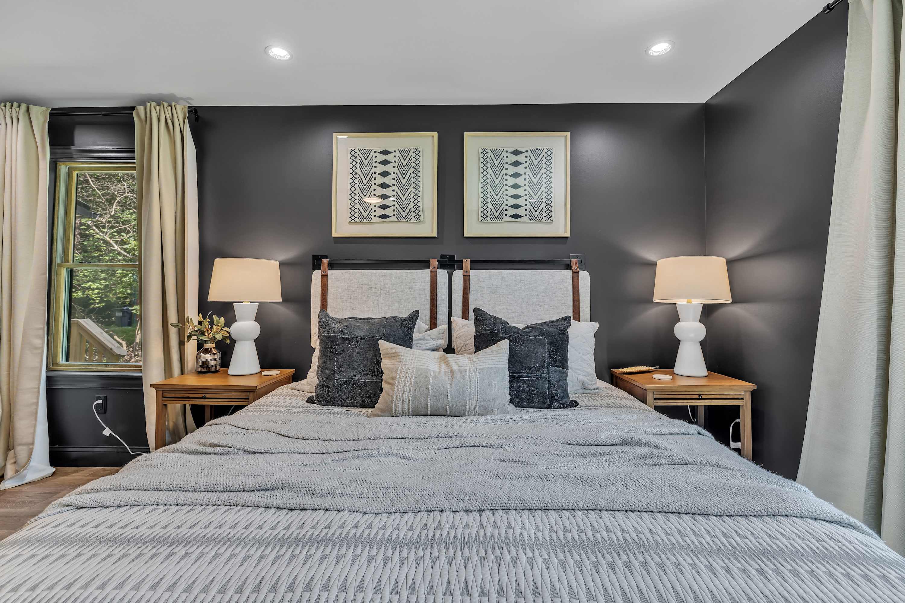Modern Elegance in the Master Suite – Thoughtful design meets comfort with moody gray walls, warm lighting, and a plush king-sized bed.