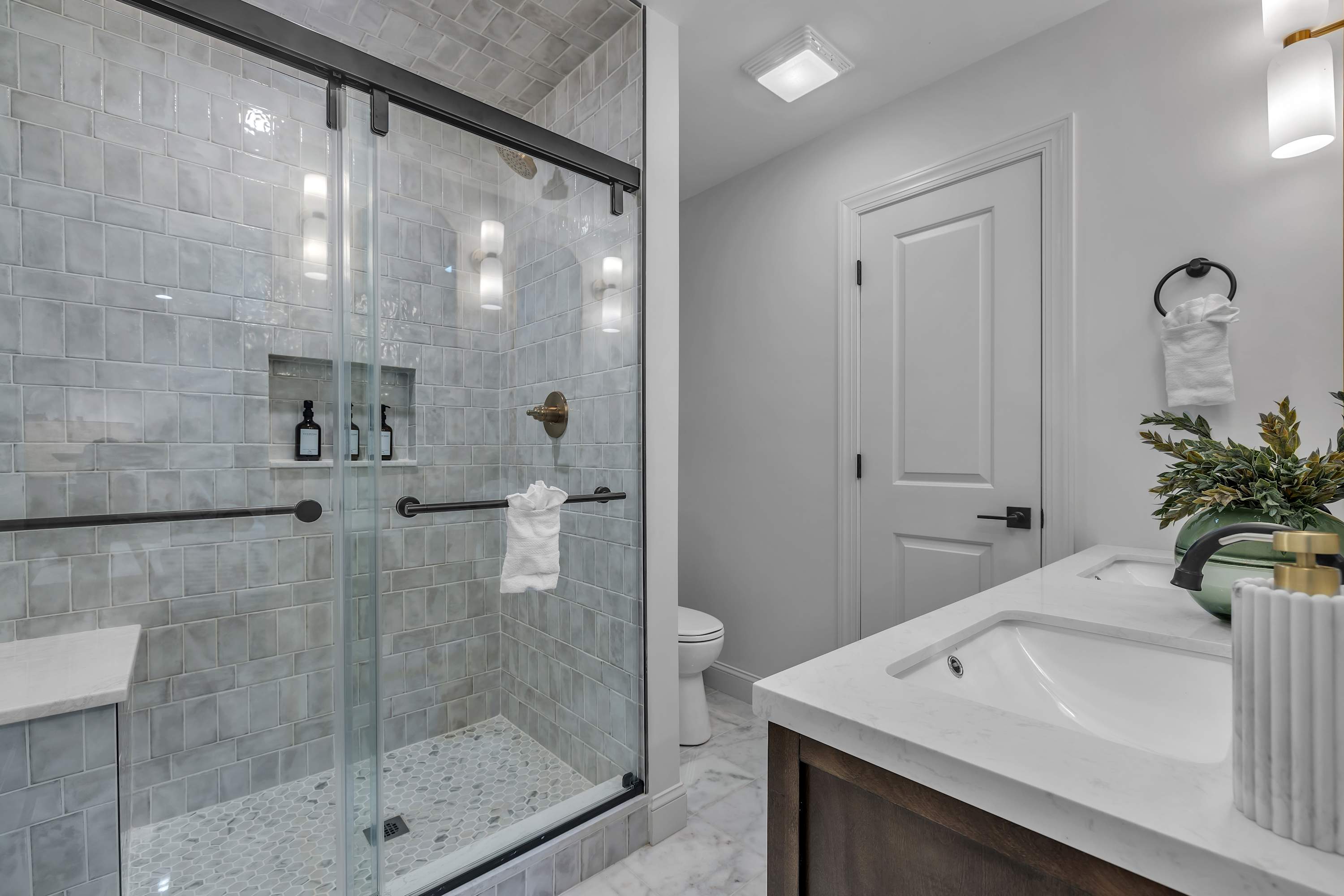 Luxury Walk-In Shower – A beautifully designed bathroom with marble tile, glass doors, and elegant fixtures for a spa-like experience.