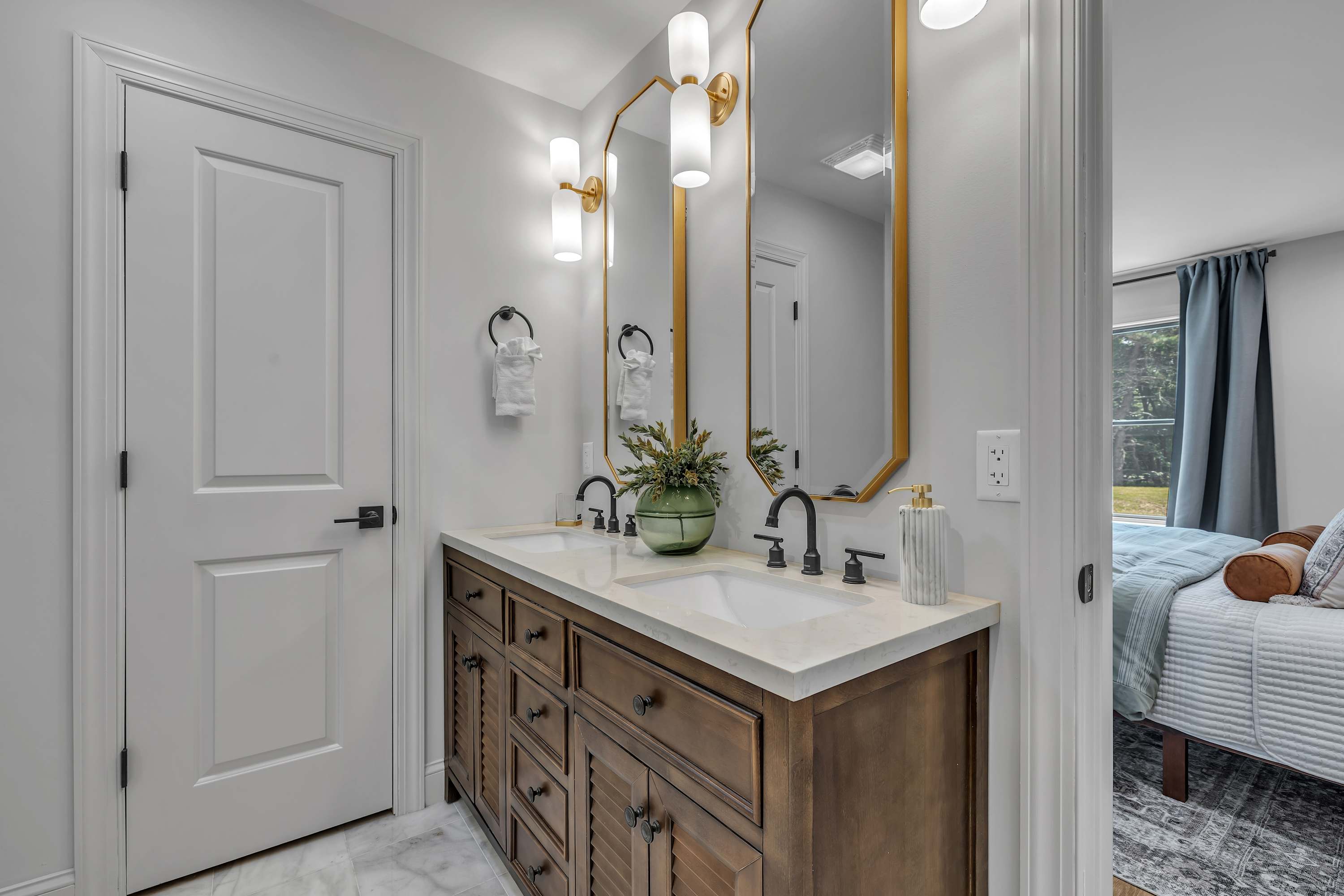 Bright & Elegant Double Vanity – A modern bathroom featuring a spacious double vanity, gold accents, and soft lighting for a refined touch.