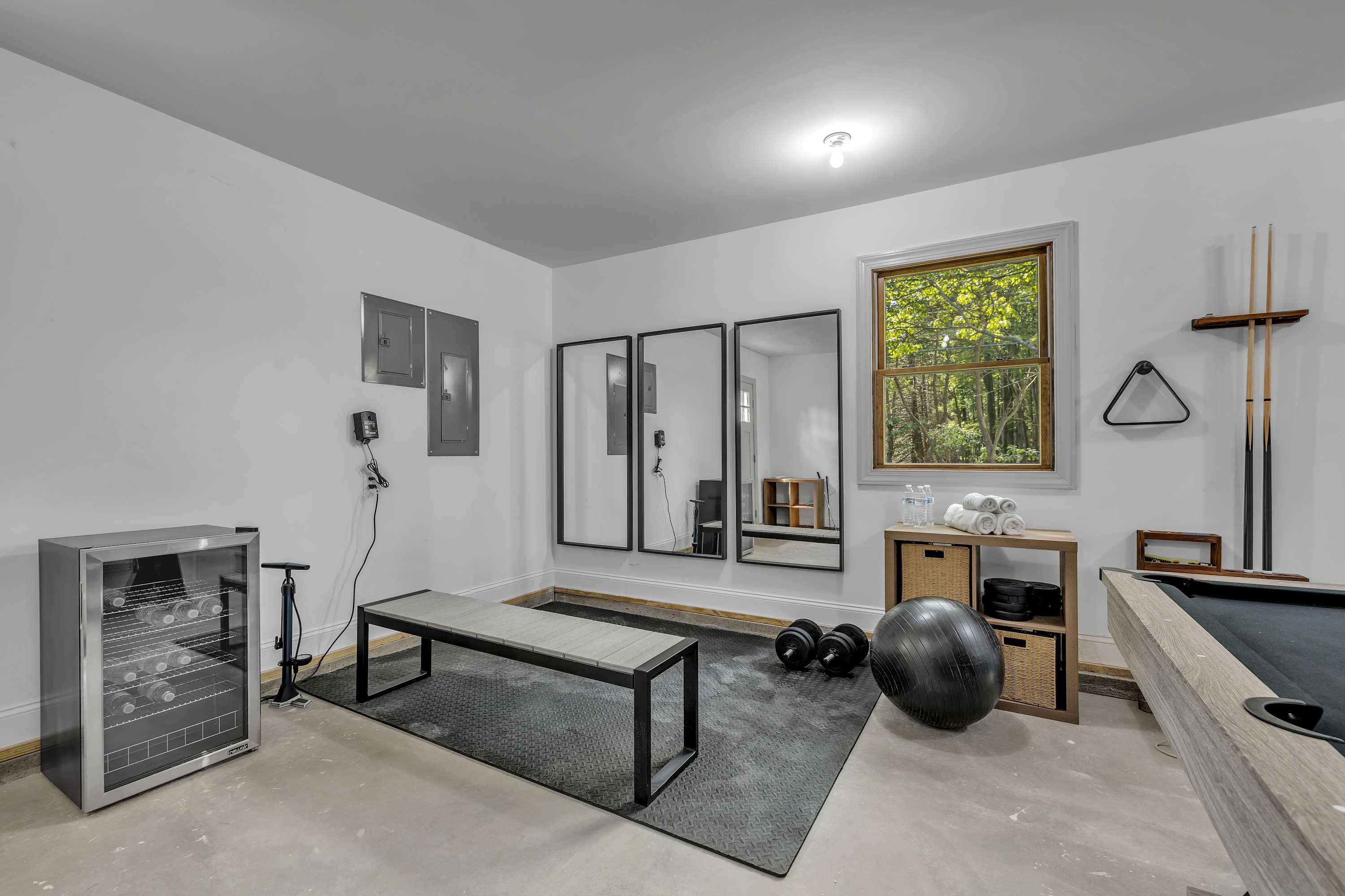 Multi-Purpose Fitness & Game Room – A versatile space equipped with workout essentials, a sleek bench, full-length mirrors, and a pool table for the perfect mix of fitness and fun.