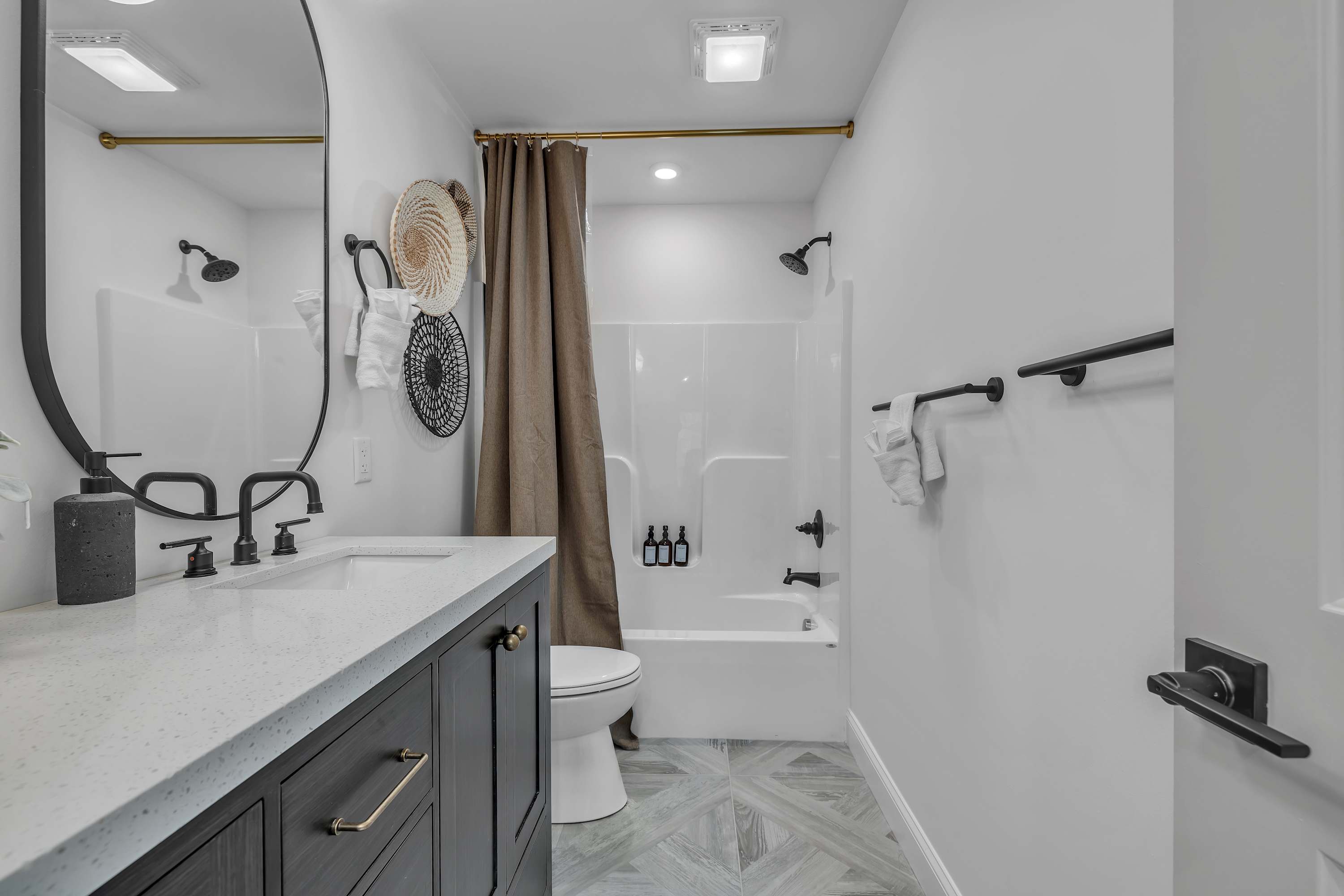 Bright & Airy Bath Retreat – A beautifully designed bathroom featuring soft neutral tones, a shower-tub combo, and stylish fixtures for a spa-like experience.