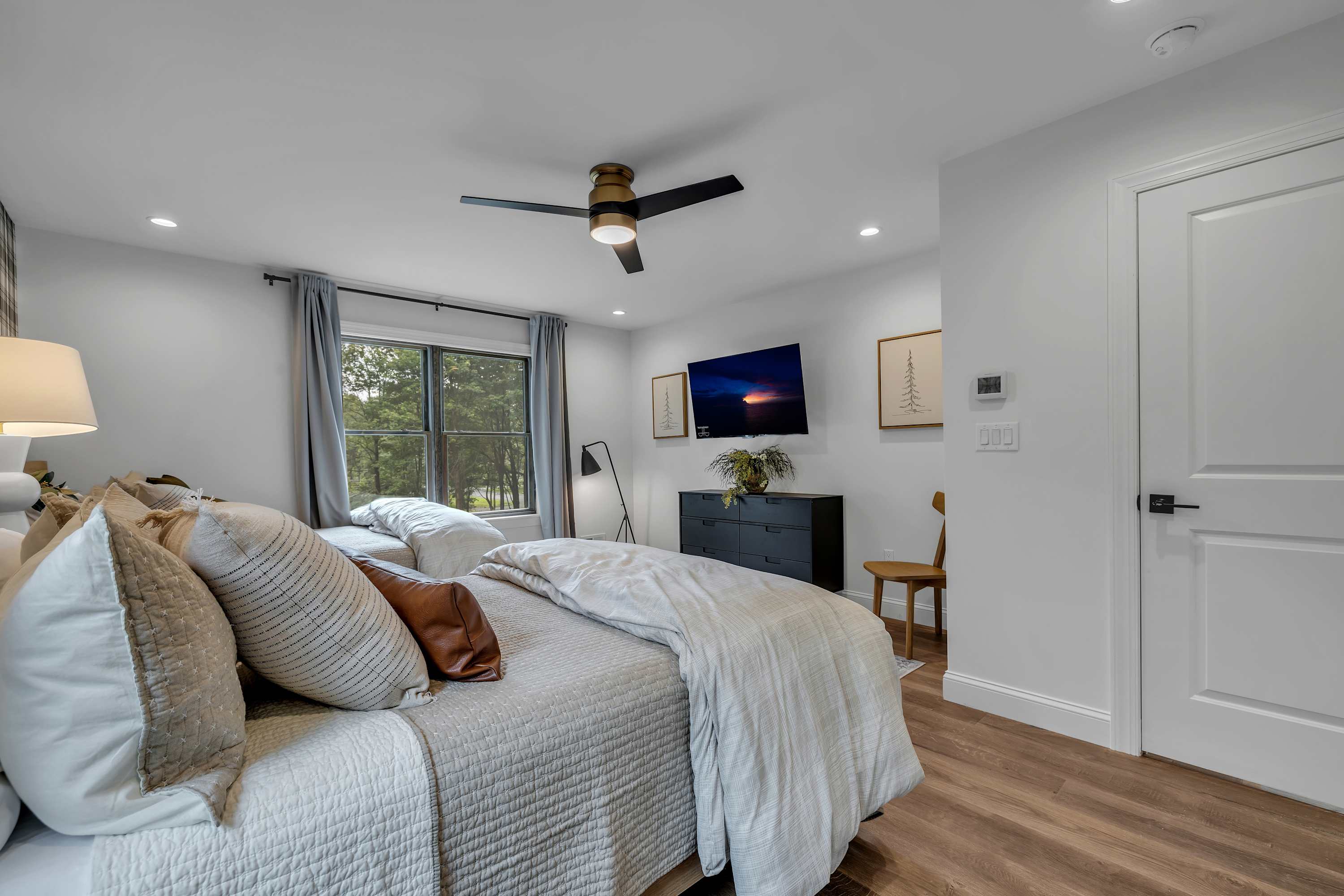 Comfort Meets Functionality – A well-designed bedroom featuring a cozy workspace, plush bedding, and warm lighting for the perfect balance of comfort and productivity.