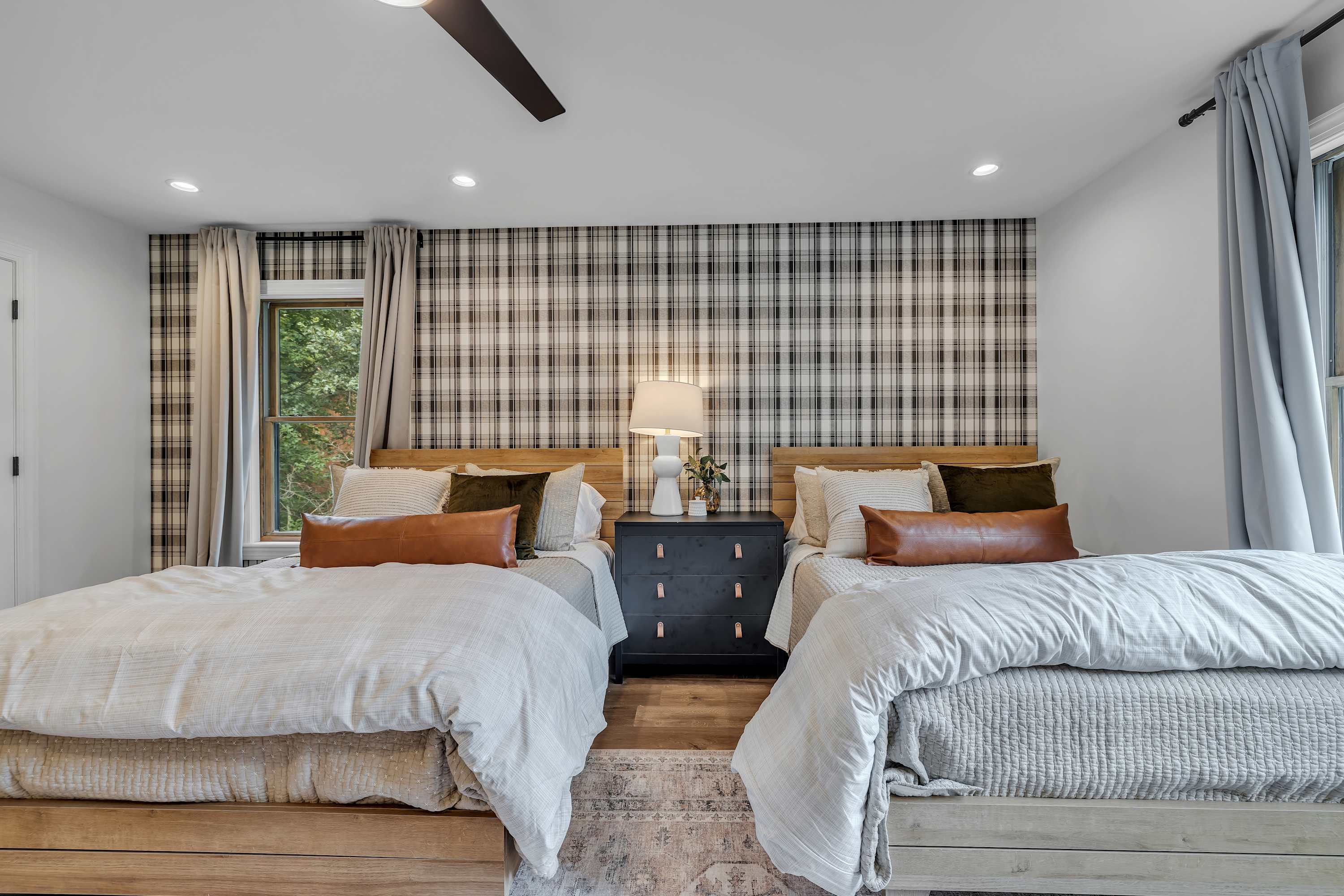 Spacious & Stylish Sleeping Quarters – Two cozy beds, soft textures, and earthy tones create a charming and functional space for families or friends.