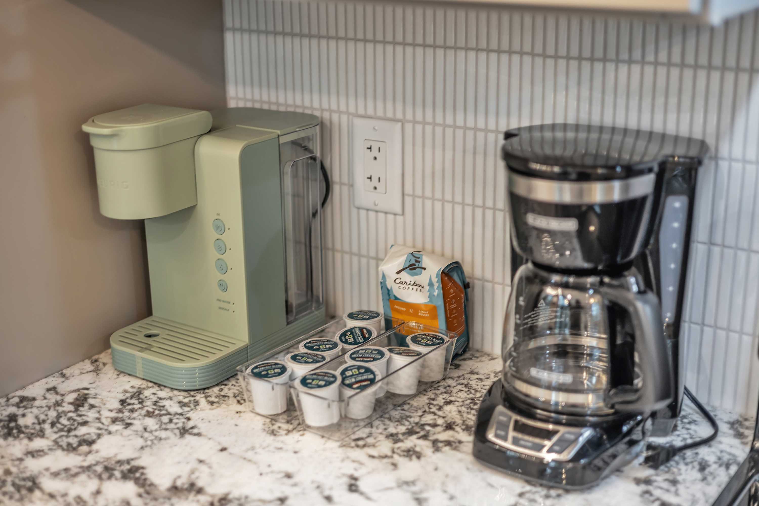 Coffee Corner with a Retro Touch – A charming coffee station featuring a pastel green Keurig, a classic drip coffee maker, and a selection of pods for the perfect morning brew.