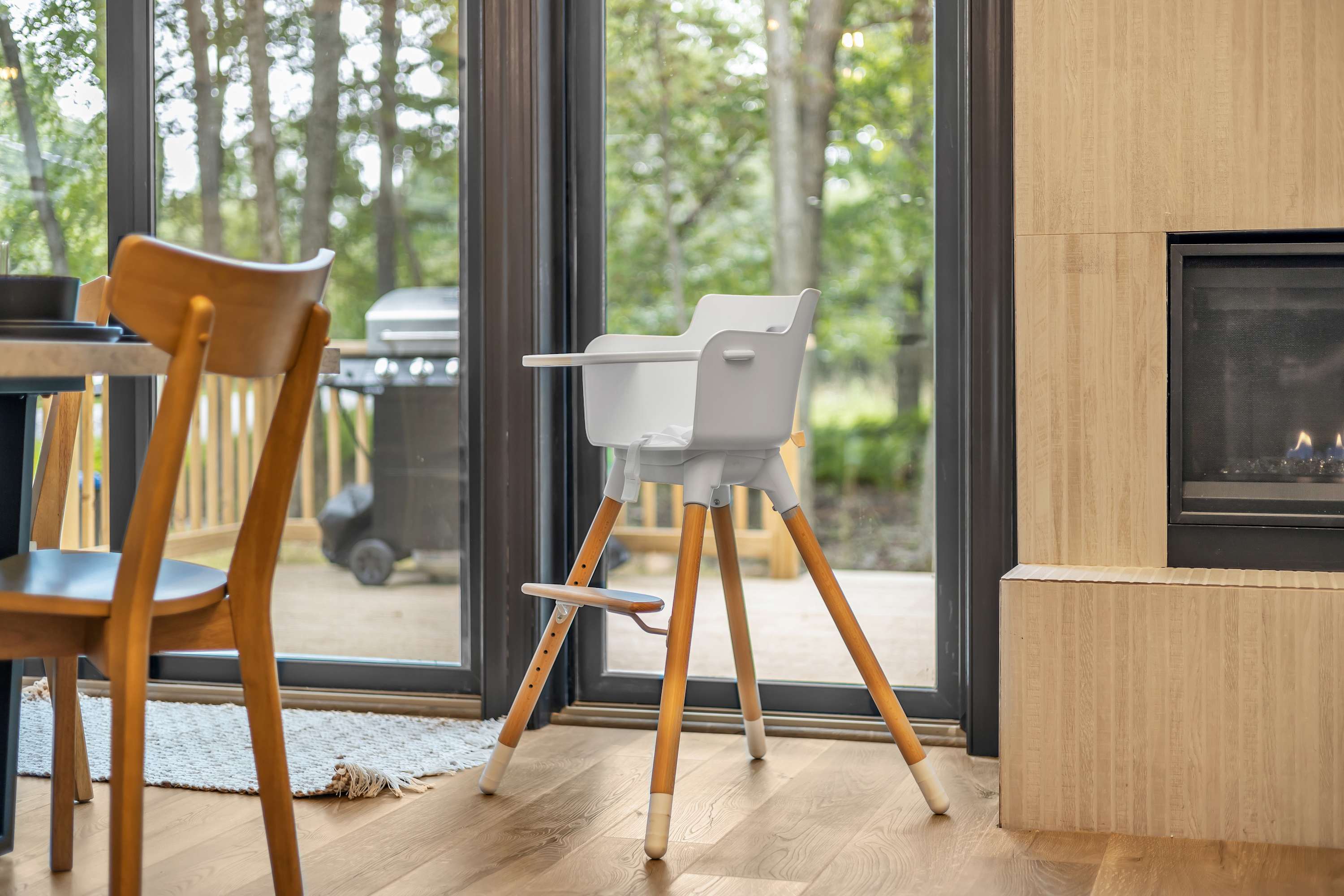 Cozy Dining with a View – A modern dining nook with stylish wooden chairs and a sleek fireplace, perfect for enjoying meals with a scenic backdrop.