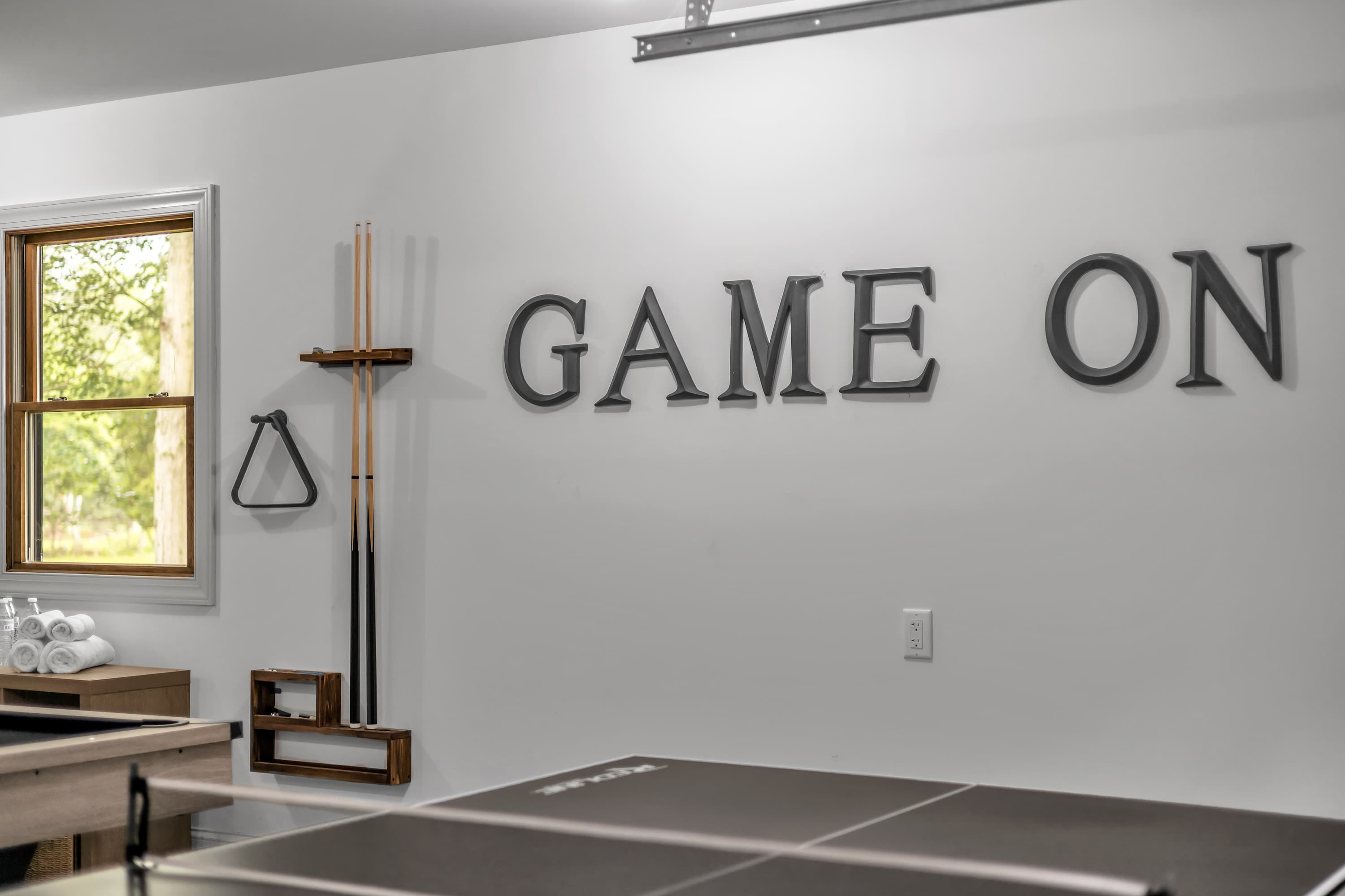Let the Games Begin – A bold "GAME ON" wall accent sets the tone in this entertainment space, equipped with all the essentials for a great time.