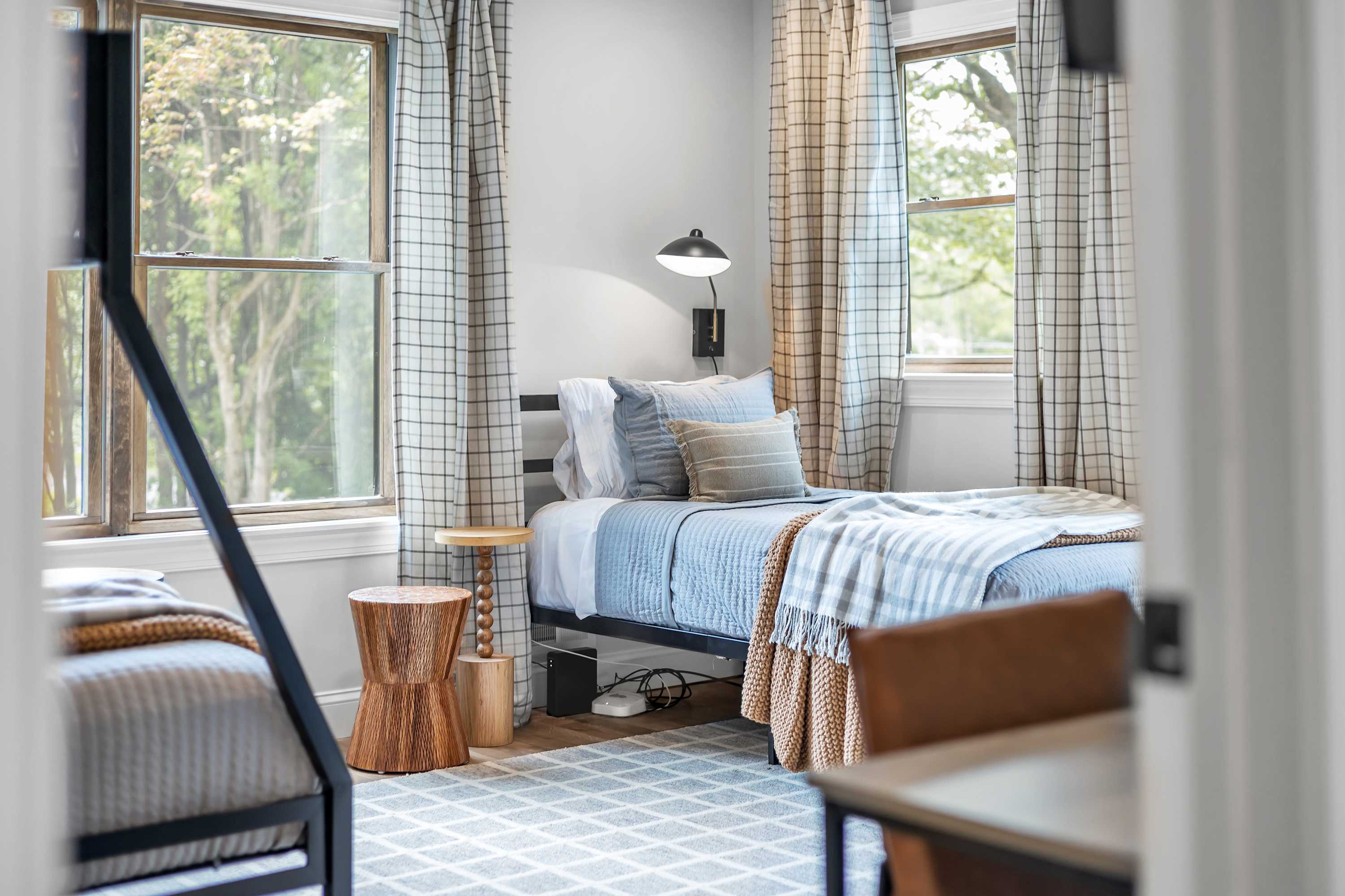 Bright & Cozy Bunk Room – A thoughtfully designed space featuring beds, warm textiles, and large windows that bring in plenty of natural light.