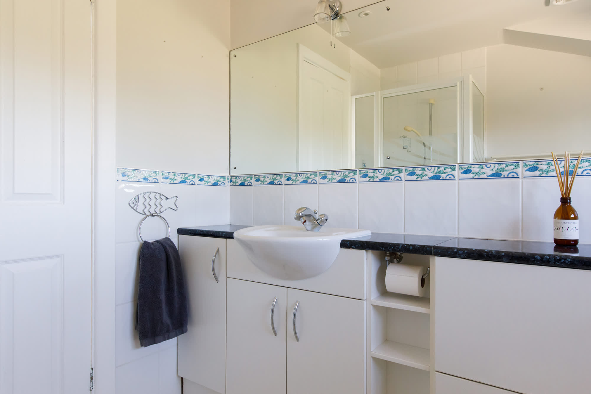 The spacious family bathroom has a large mirror, WC, sink and shower.