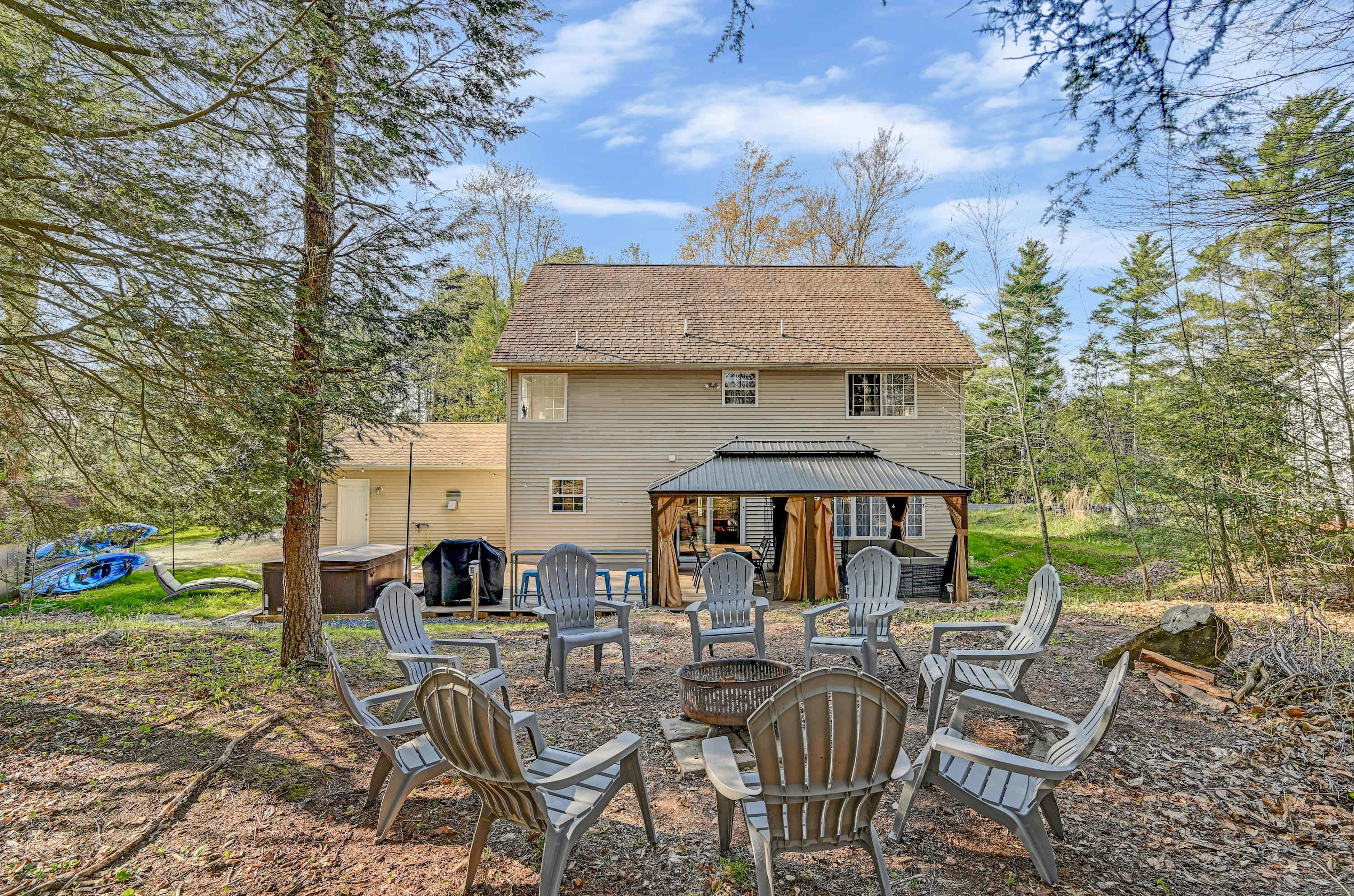 Nature Meets Comfort! Enjoy fresh air and good company in this peaceful backyard retreat, complete with a cozy fire pit setup.