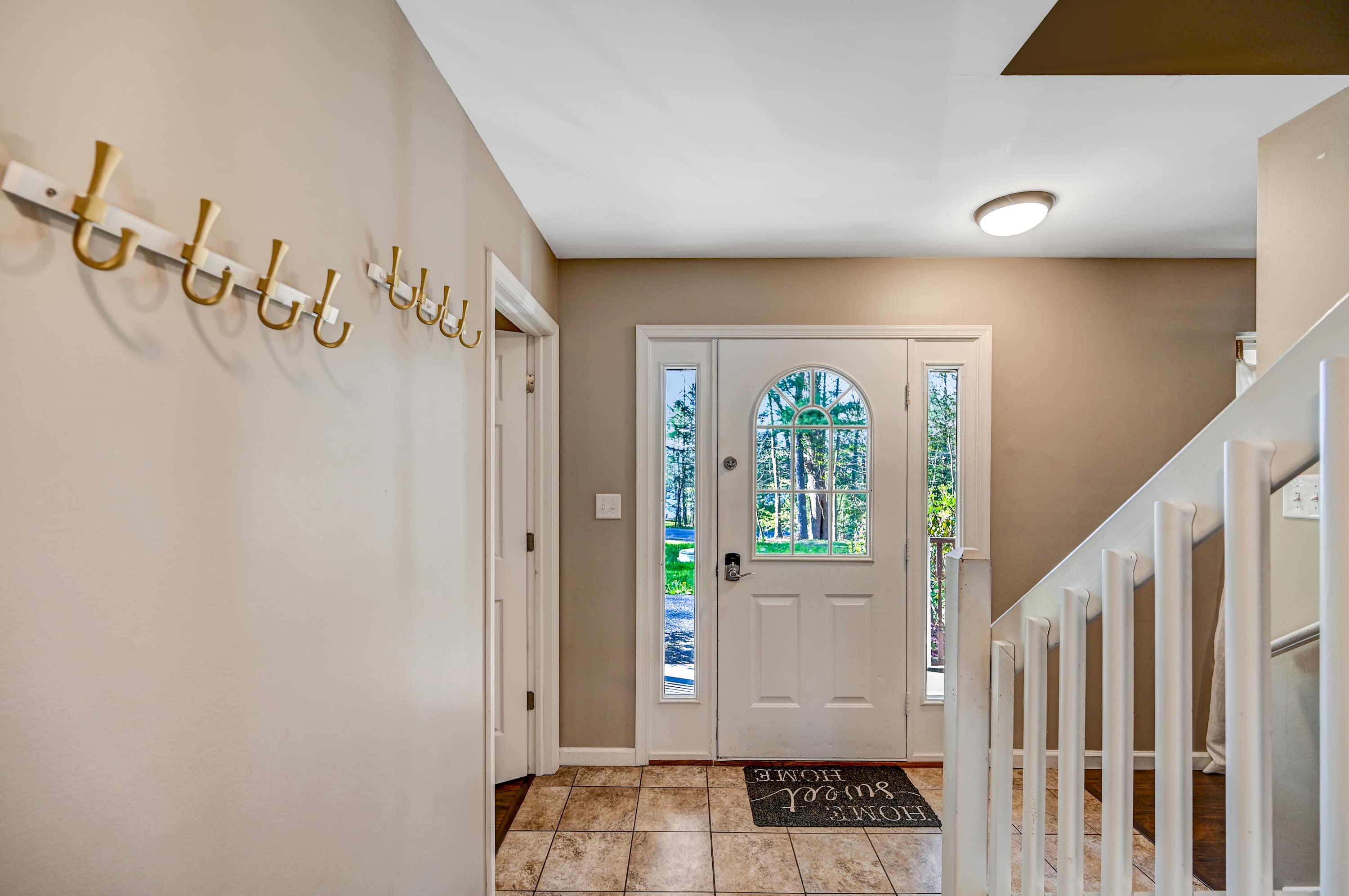 Bright & Inviting! Step into a warm and welcoming foyer with natural light, stylish coat hooks, and a spacious layout, perfect for greeting guests.