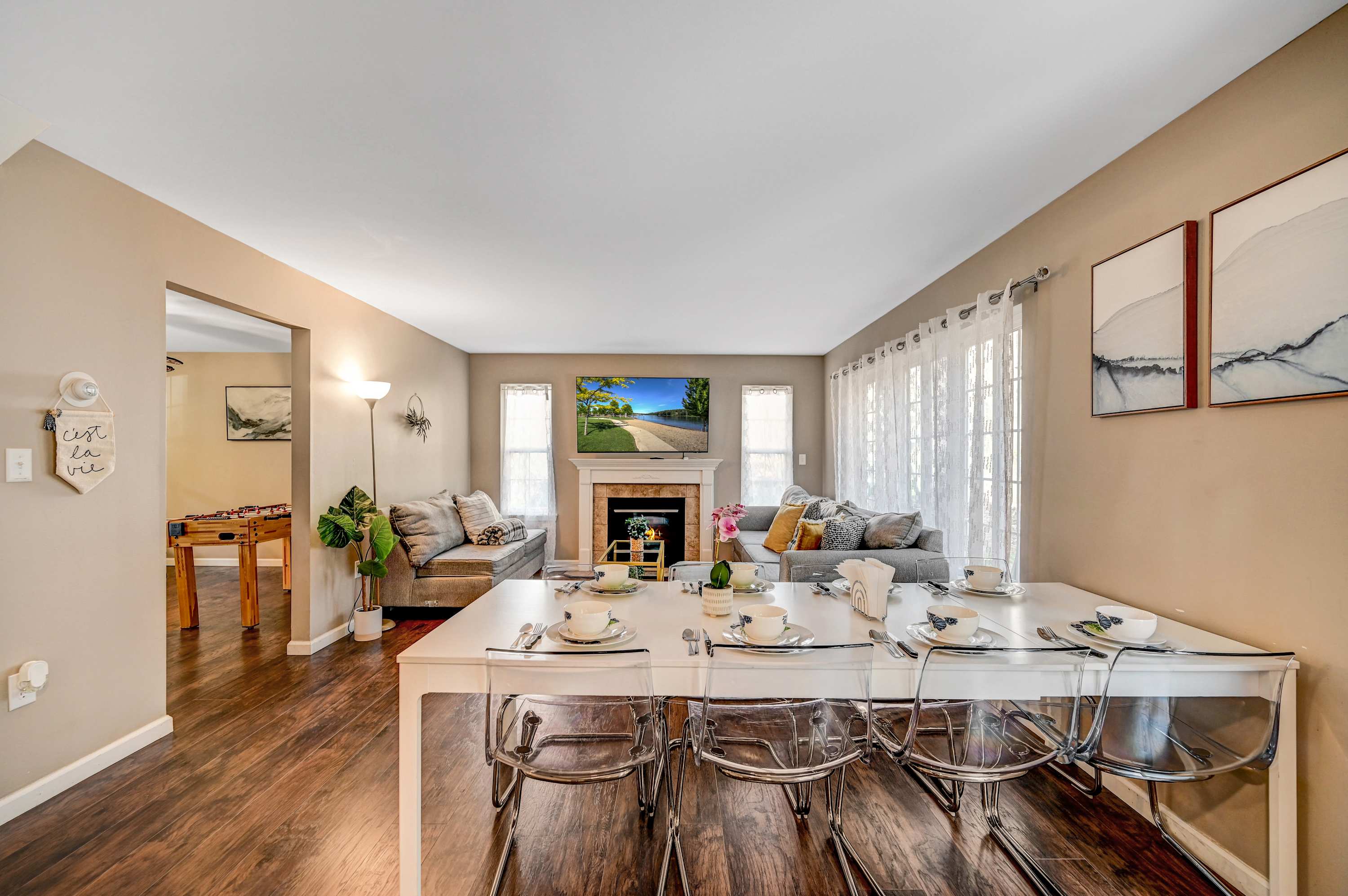Cozy & Inviting! This open-concept living and dining area offers a comfortable retreat with a modern fireplace, chic decor, and ample natural light.