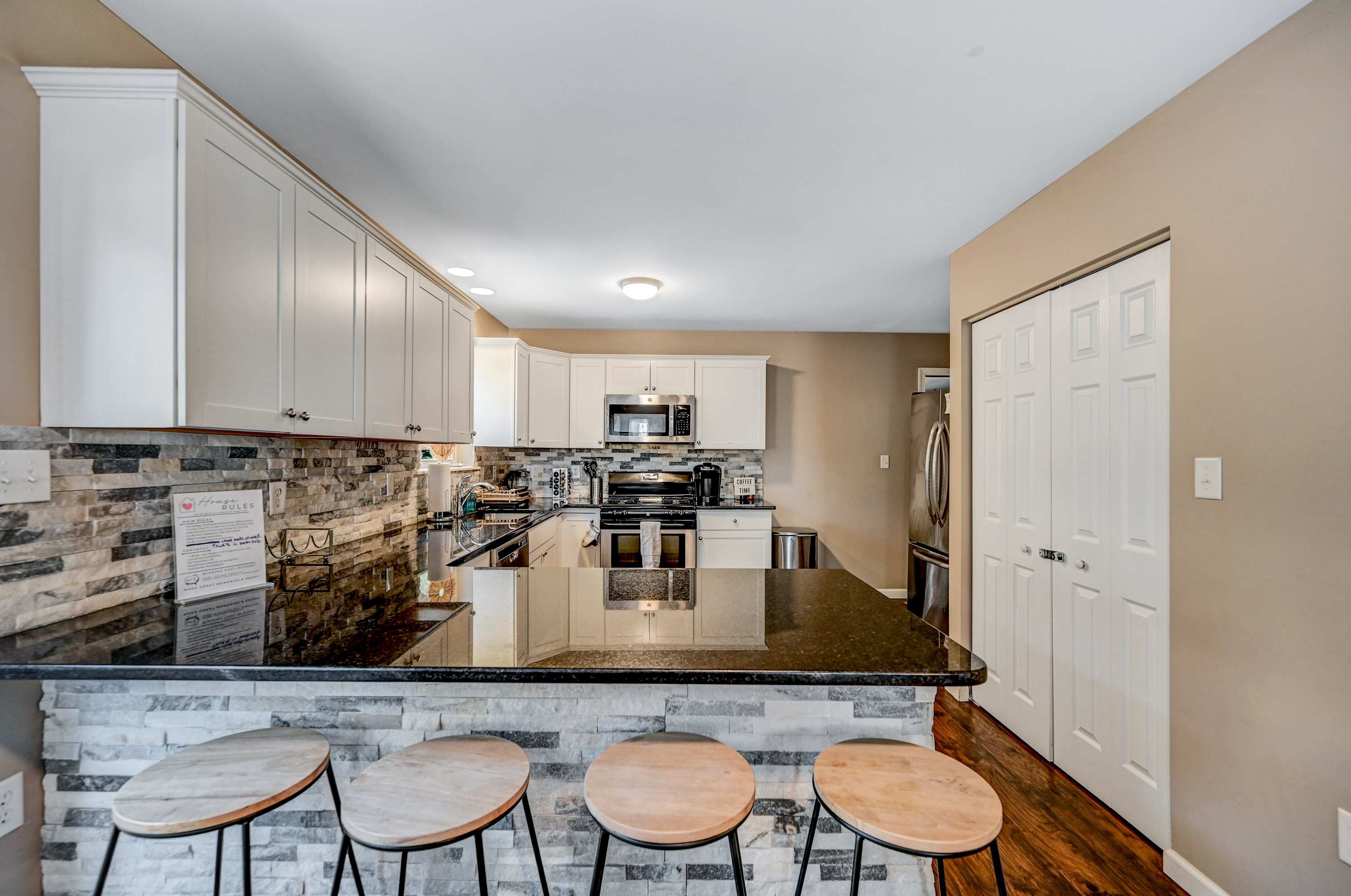 A Kitchen That Invites You In! The mix of stone, wood, and bright accents makes this space both cozy and sophisticated. Slide open the doors, let the fresh air in, and enjoy!