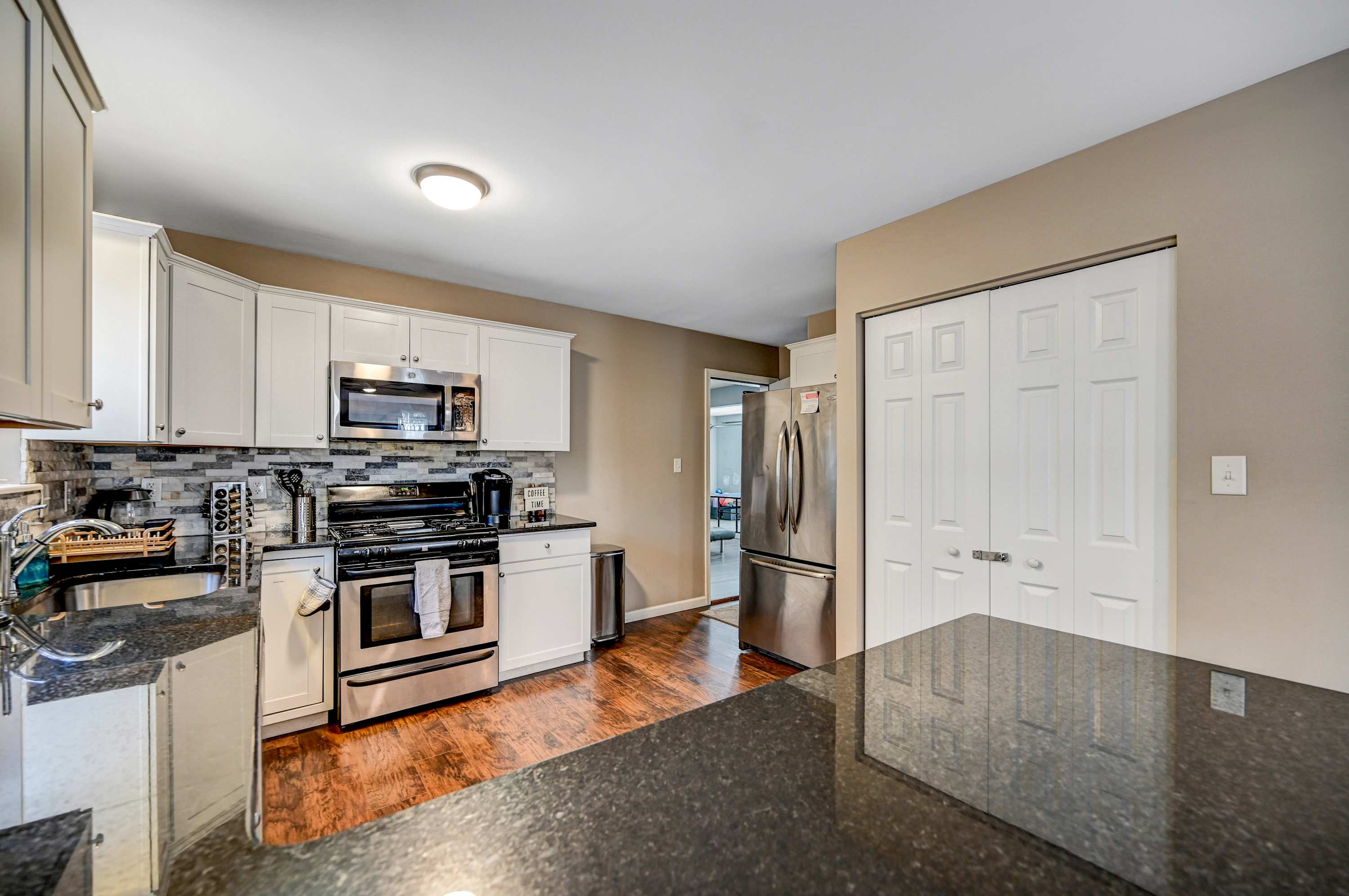 Where Style Meets Function! Bright cabinetry, sleek granite countertops, and modern appliances make this kitchen a dream for home cooks and entertainers alike. 