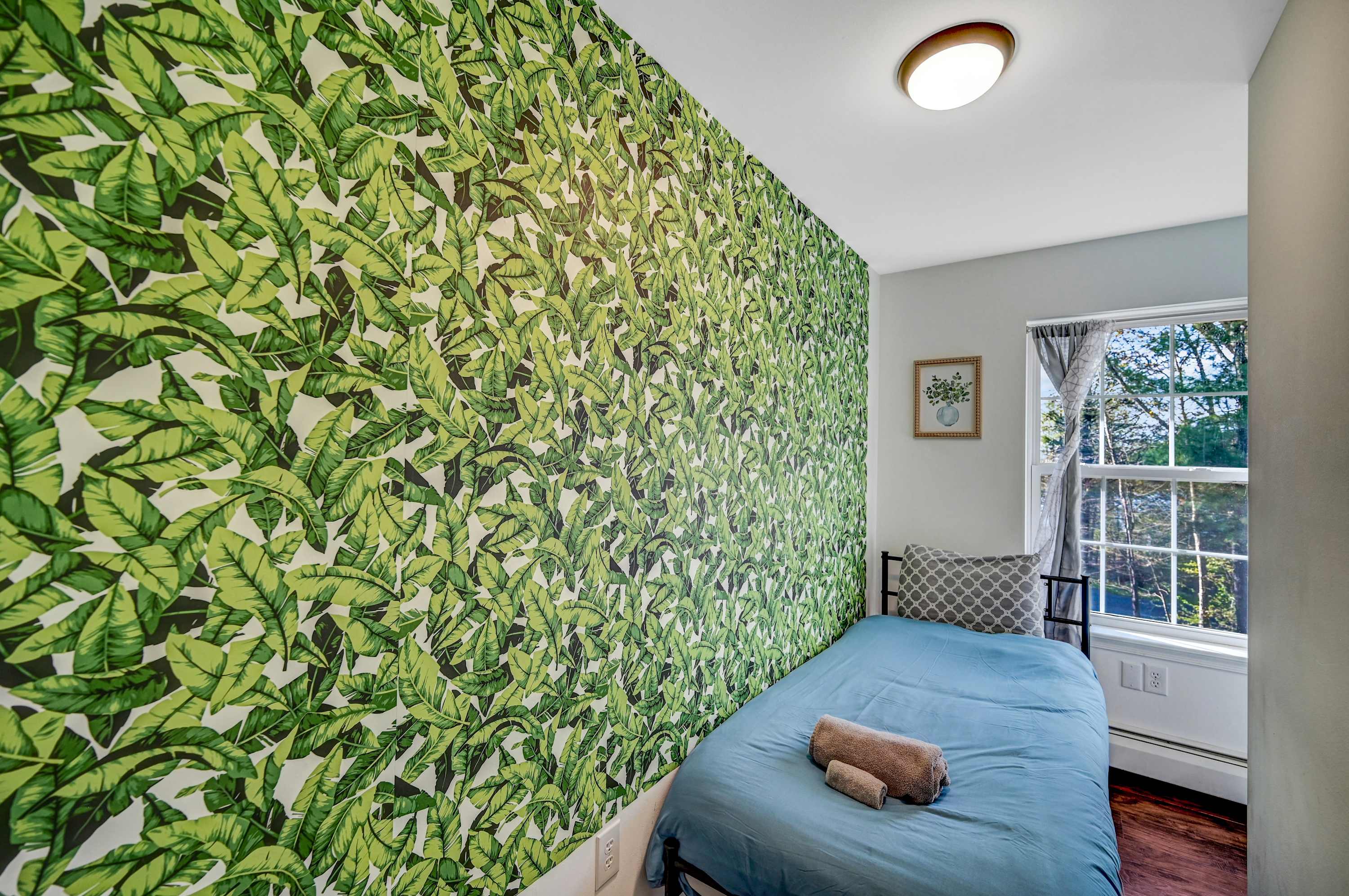 Sunlit & Stylish Escape! A perfect blend of cozy and creative, this bright bedroom features a nature-inspired theme, a comfy bed, and a relaxing window view.