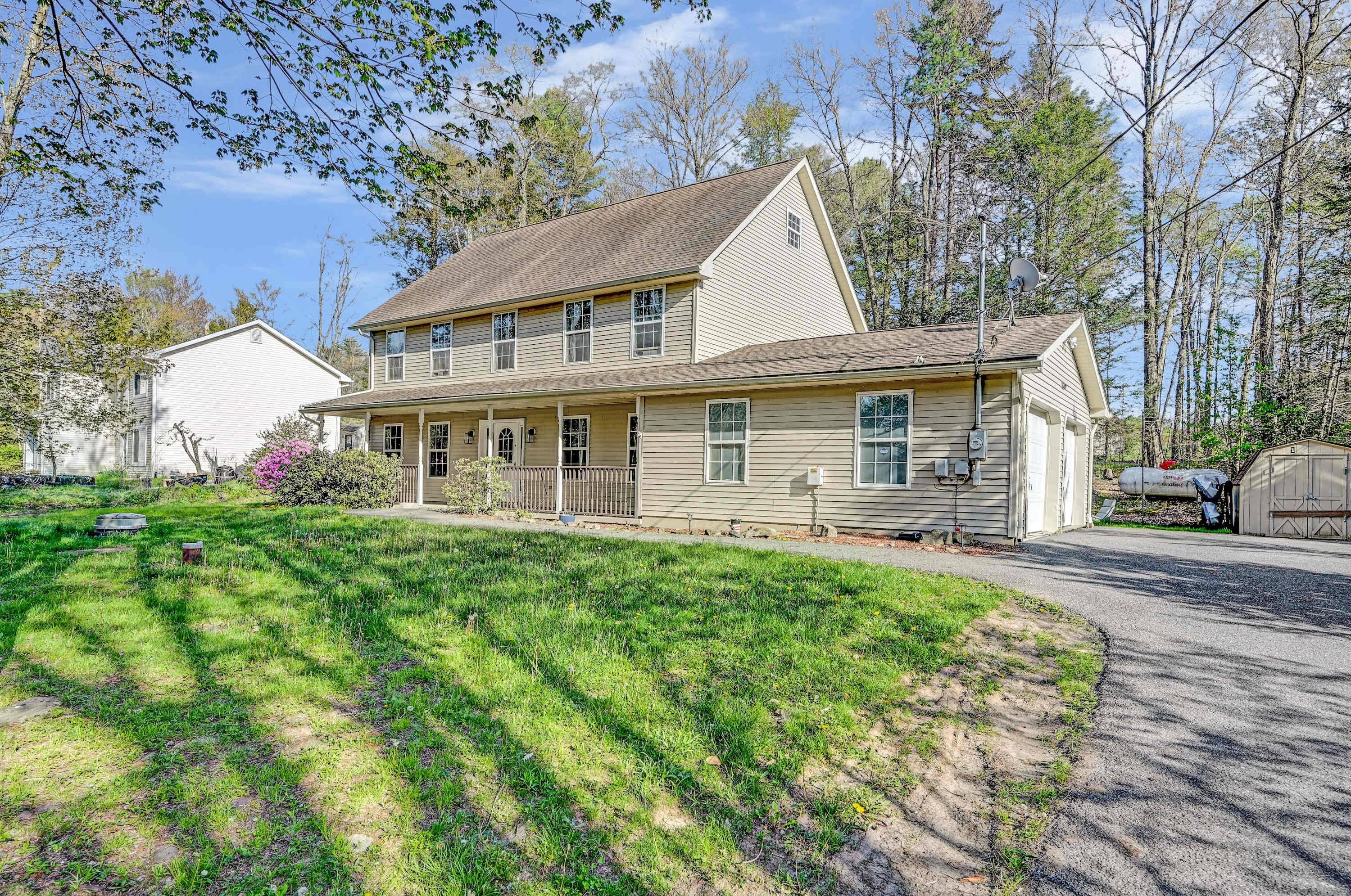 Warm & Welcoming! This home greets you with a cozy porch, ample parking, and lush greenery, a perfect countryside escape.