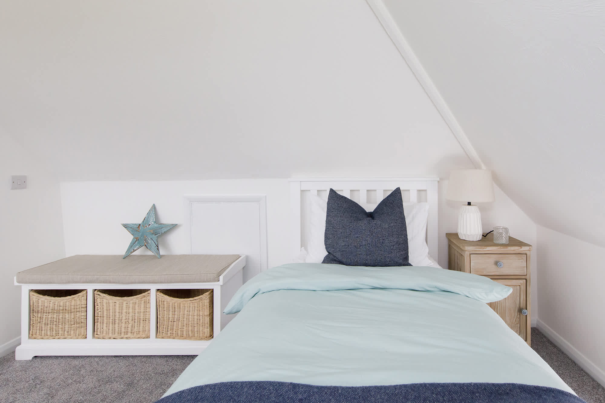 The loft room has a comfy single bed with partial sea views.