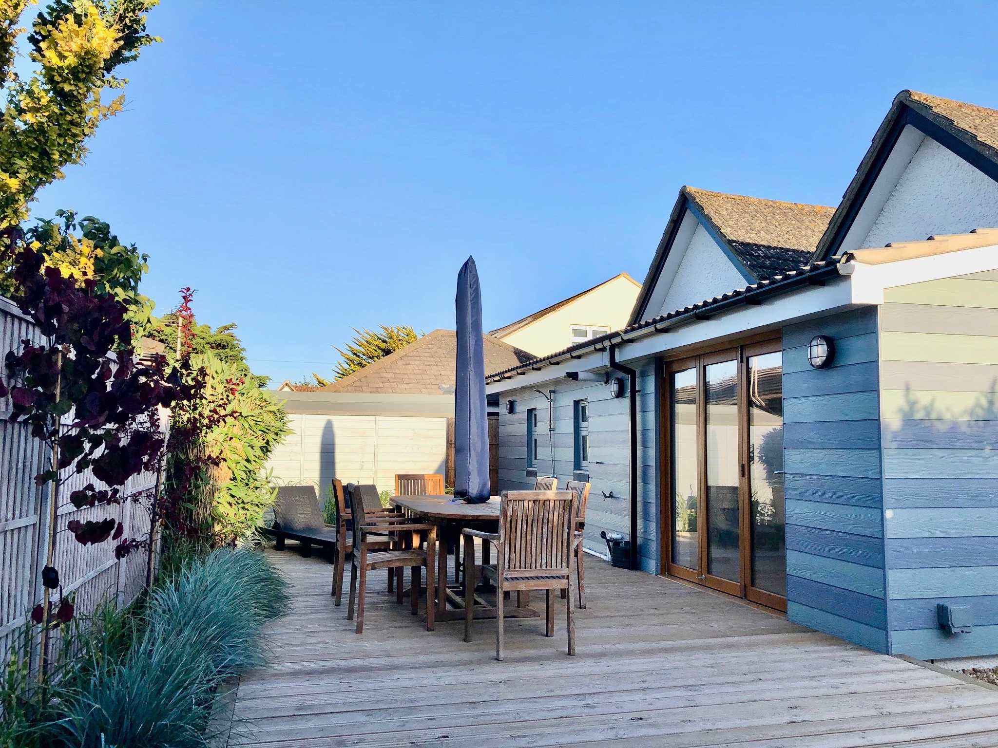 Sunny decked area with outdoor dining, ideal for enjoying meals after a beach day.