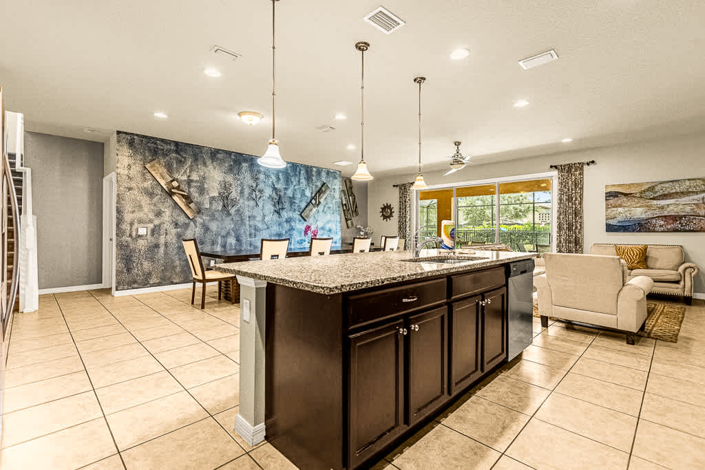 Spacious open-plan kitchen and living area with modern decor and abundant natural light, perfect for entertaining and relaxation.