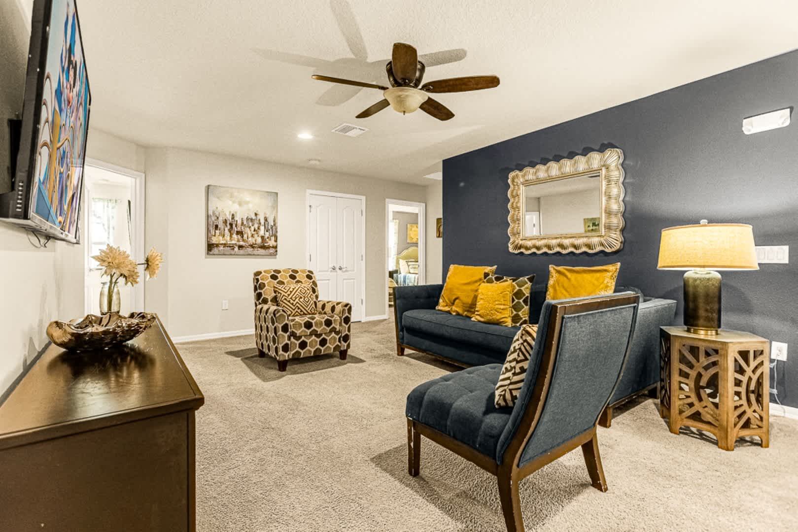 Unwind in this chic living room with plush seating, vibrant decor, and a large TV, perfect for relaxation.