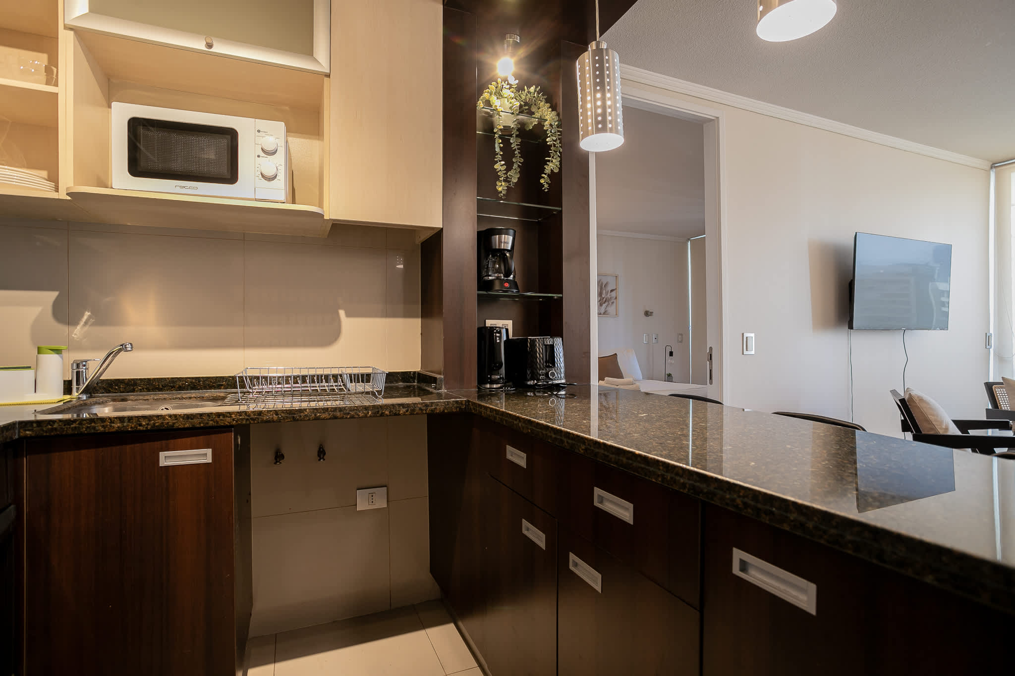 Modern kitchen with sleek granite countertops and convenient appliances, perfect for a cozy stay.