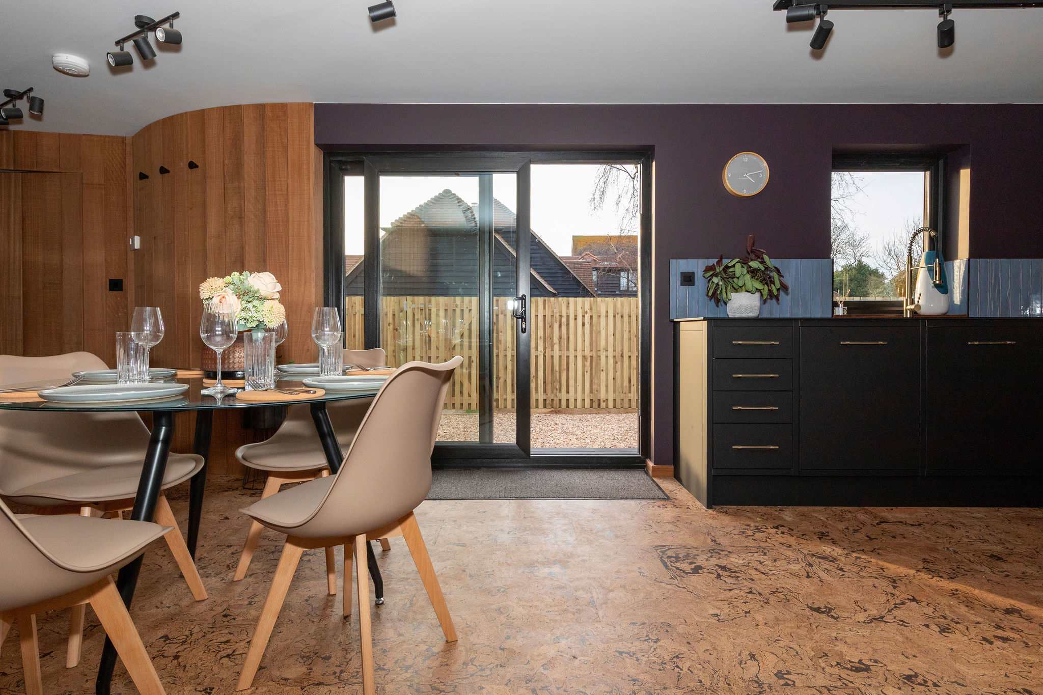 The sliding doors open out to the gravel driveway.