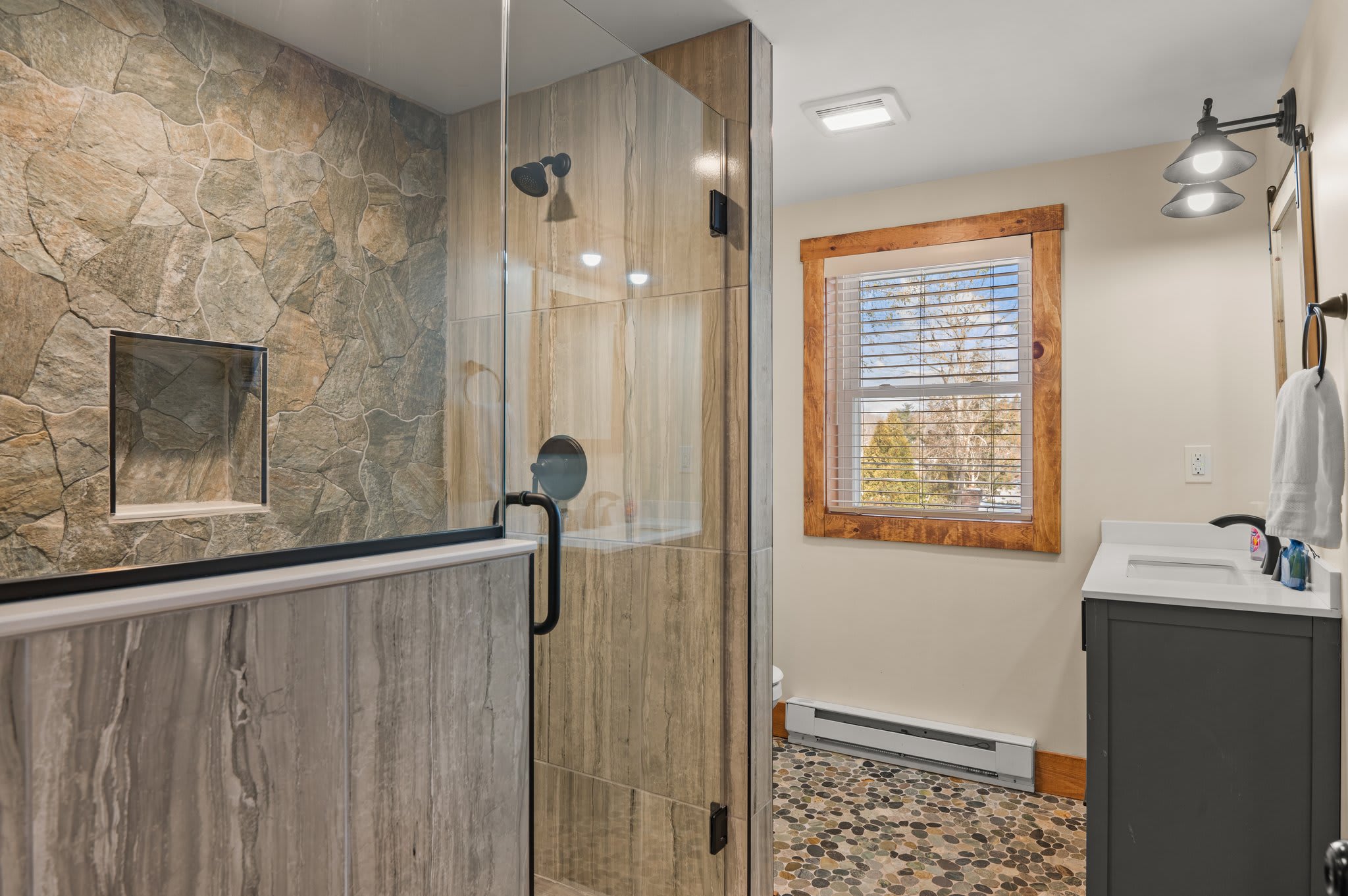 Elegant Stone Shower
A beautifully tiled walk-in shower with glass doors and rainfall head adds a luxe touch to your stay.