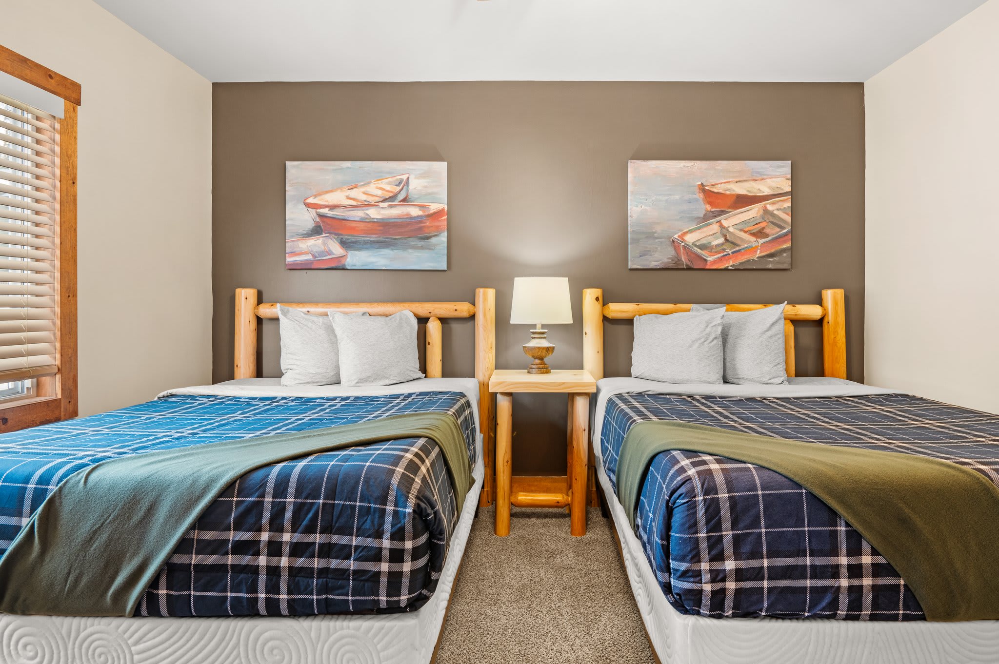 Bright and Balanced
Soft plaid bedding, wood accents, and natural light create a calm and welcoming bedroom setup.