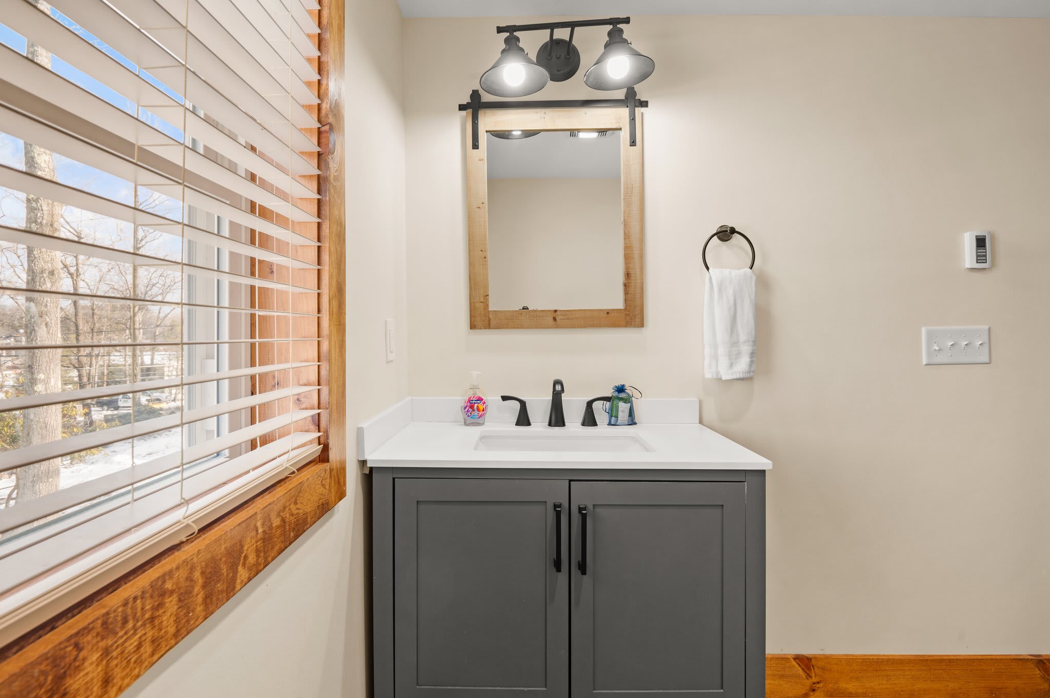 Well-Lit Vanity Space
Rustic charm meets modern ease with this sink area framed by wood tones and soft lighting.