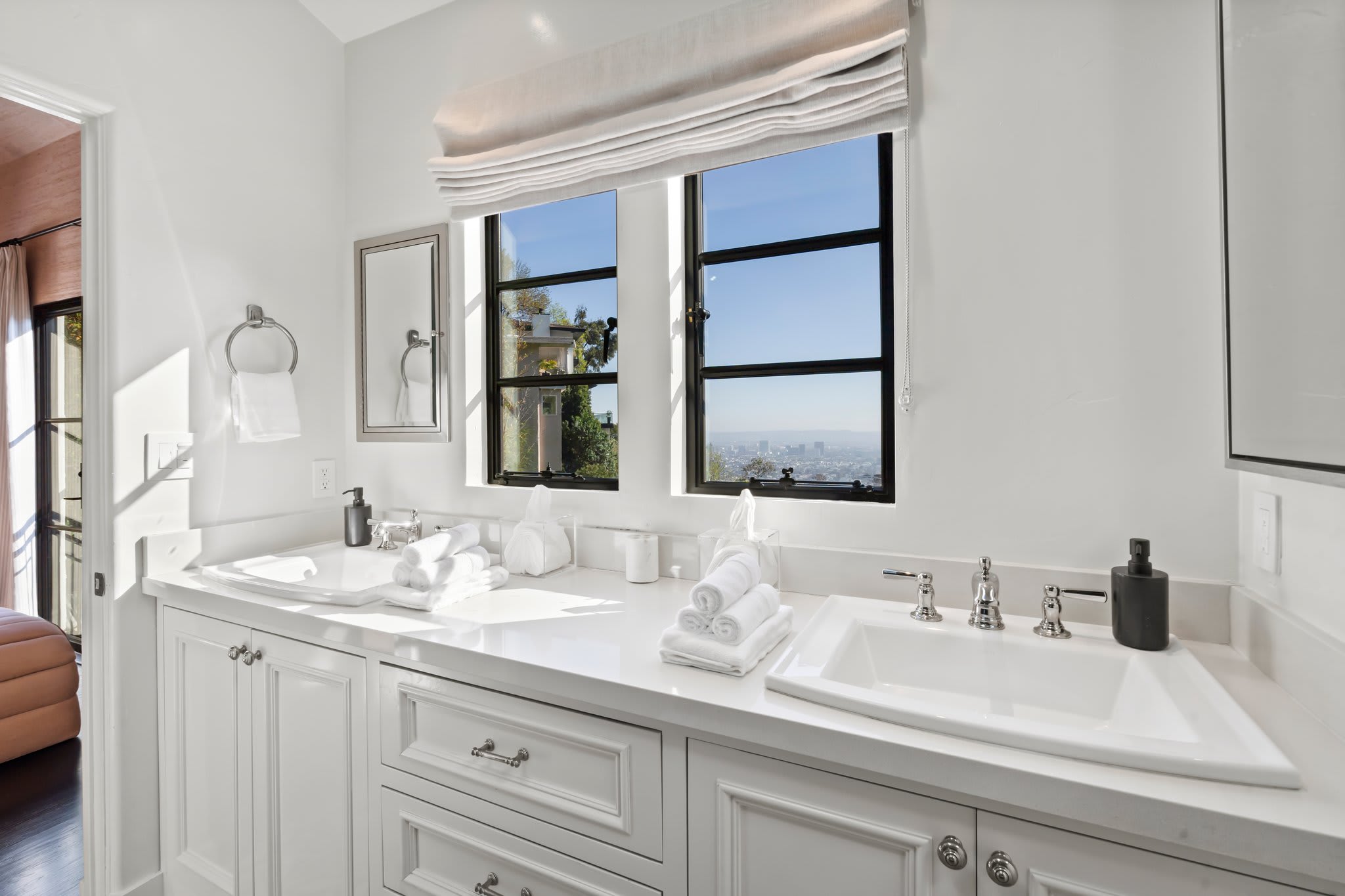 Refresh in a sunlit ensuite with a double vanity and skyline views.