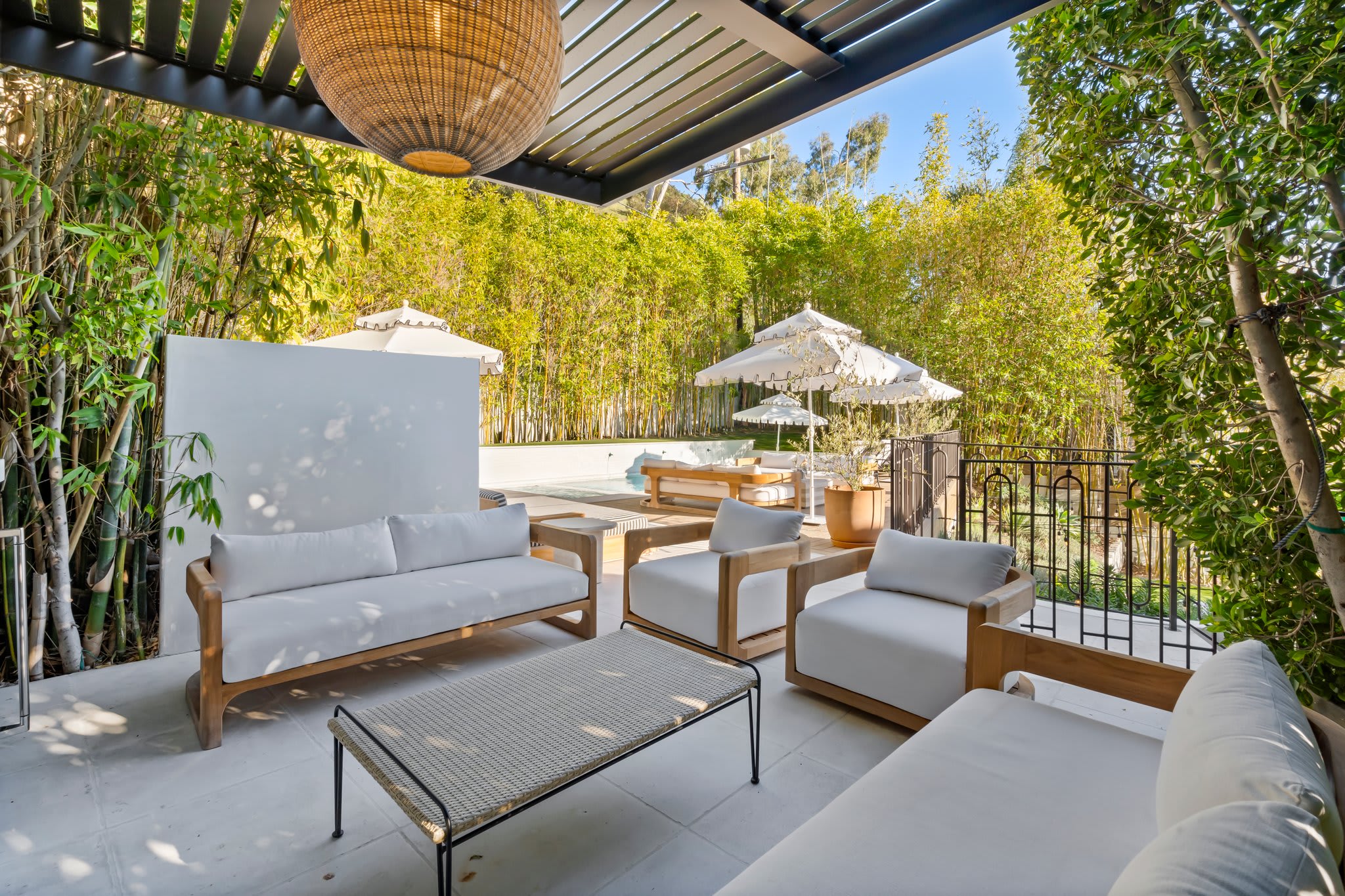 Sleek wood furniture, a shaded pergola, and everything you need for laid-back luxury.