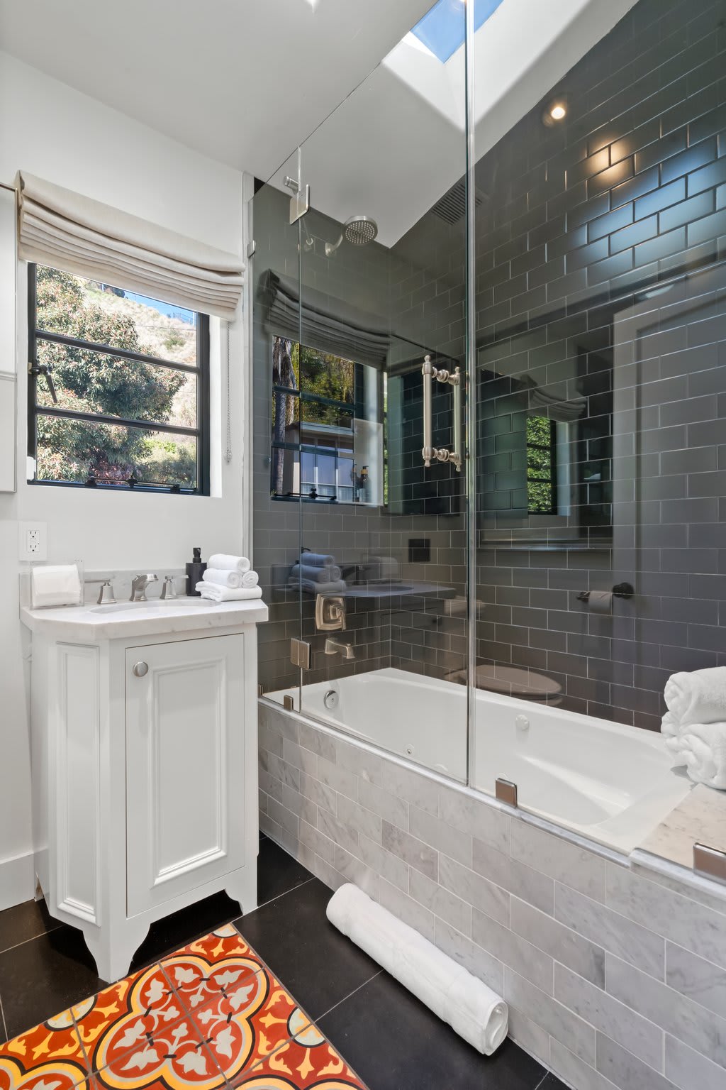 Indulge in a deep soaking tub with a sleek glass-enclosed rain shower.
