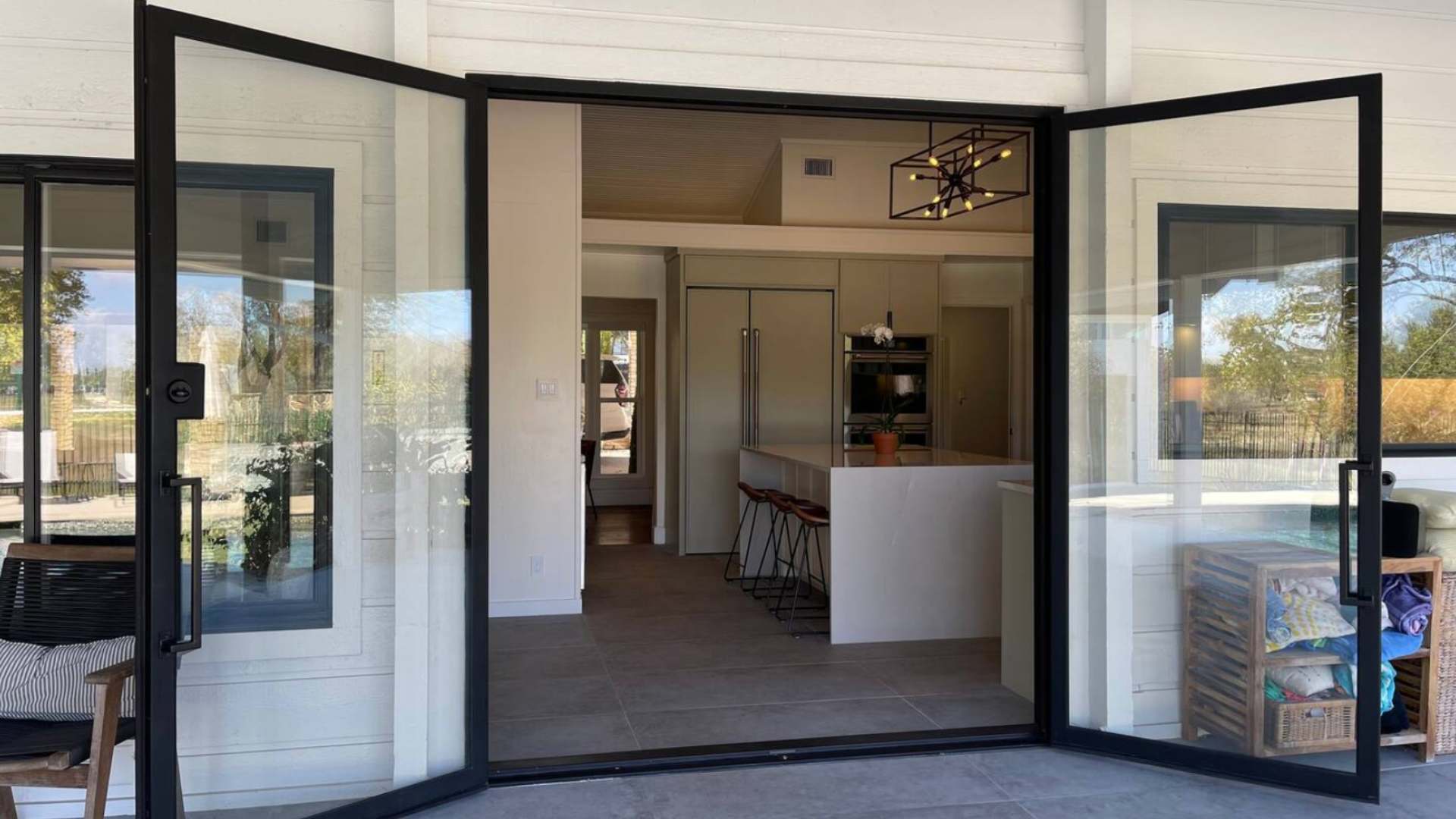 Stunning large glass doors separating the modern interior from the refreshing patio