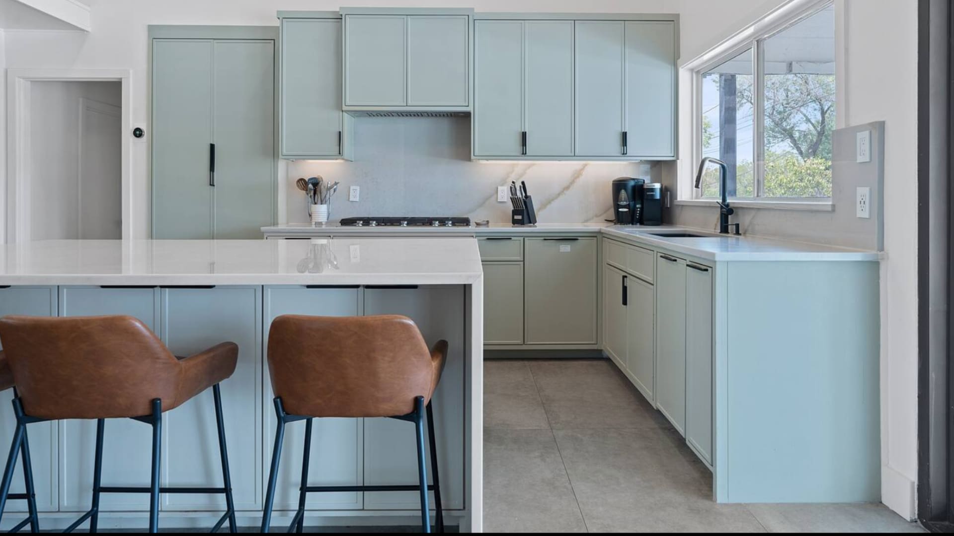 Modern kitchen with centered island and stylish leather bar seating