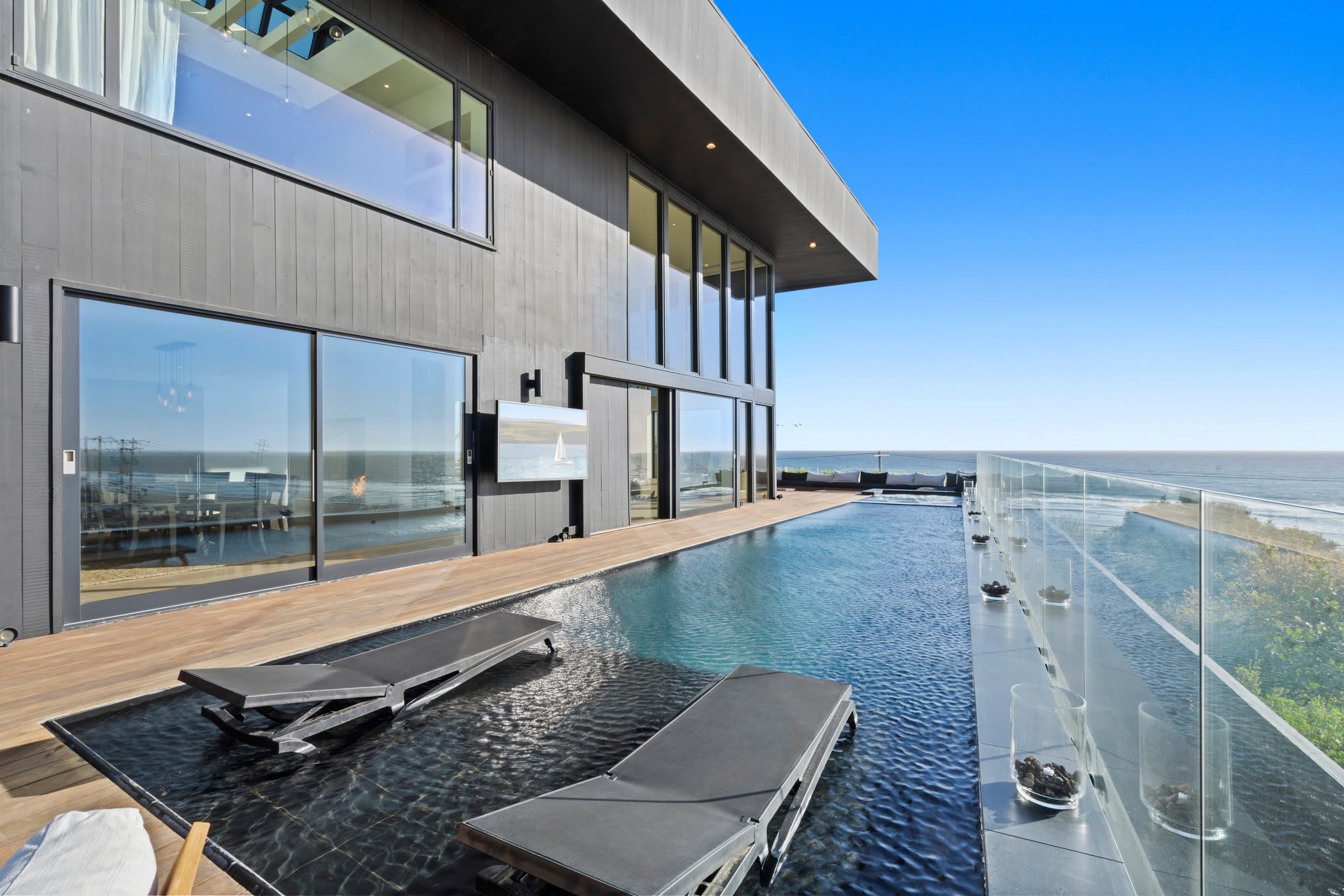 Lounge poolside with nothing but blue skies and endless water ahead.