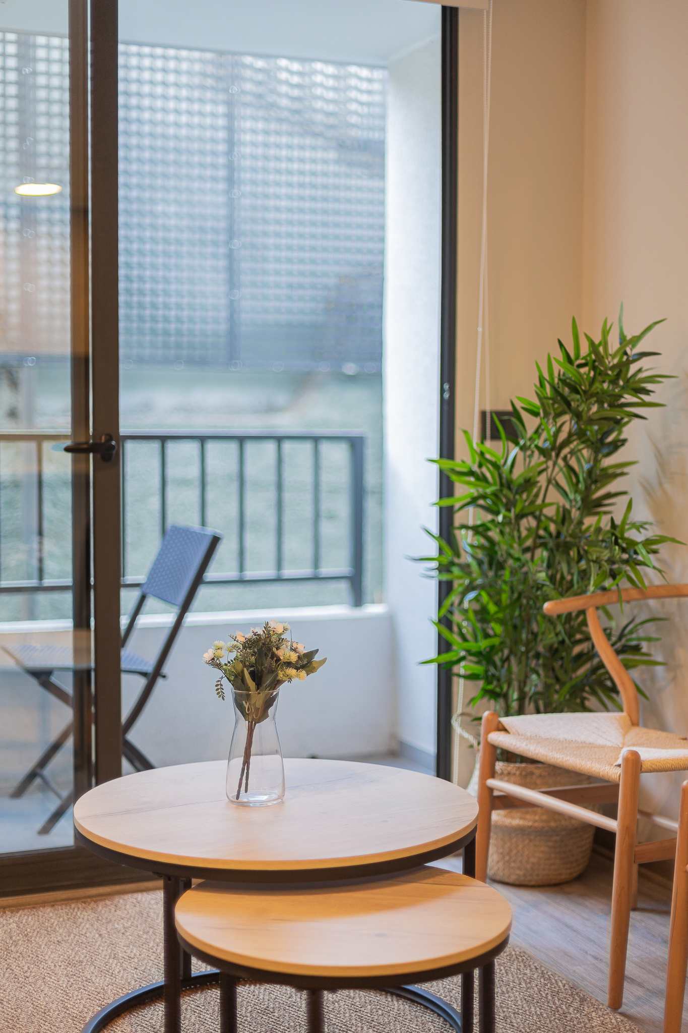 Enjoy a peaceful moment on your private balcony with a cozy seating area and lush greenery.