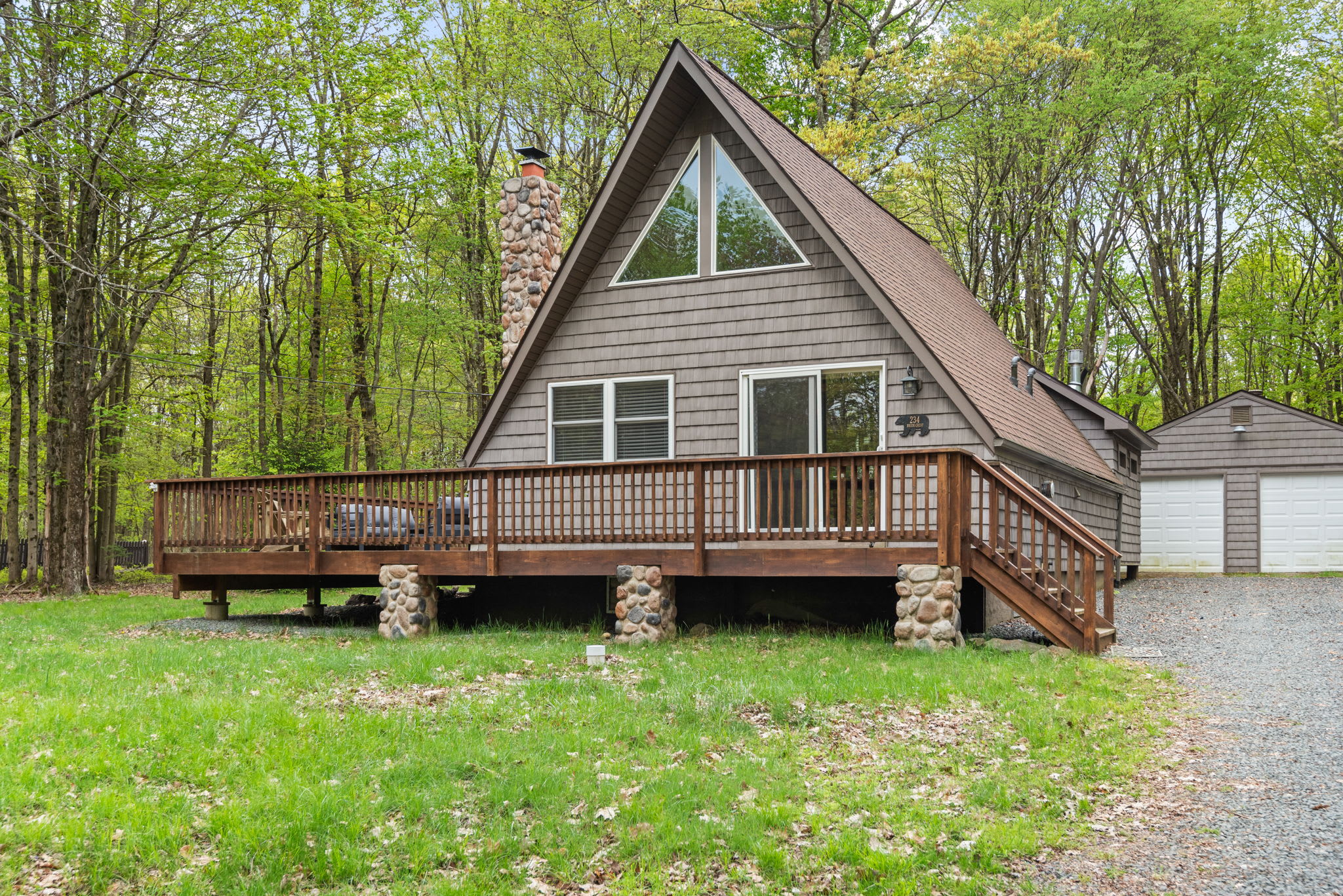 Nestled among the trees, this classic A-frame cabin exudes rustic charm with its large wooden deck and stone chimney. A peaceful retreat for nature lovers, offering seclusion and tranquility.