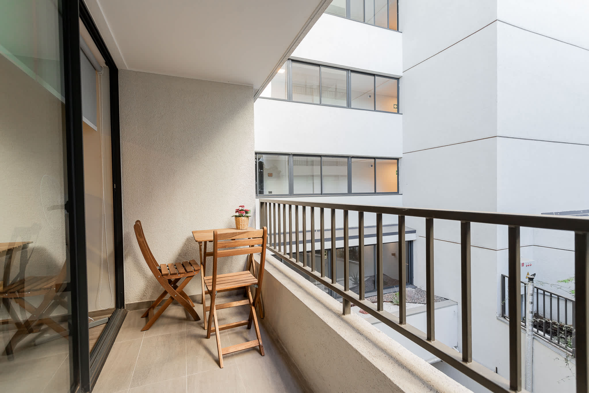 Enjoy a peaceful morning coffee on your private balcony with charming views of the modern cityscape.