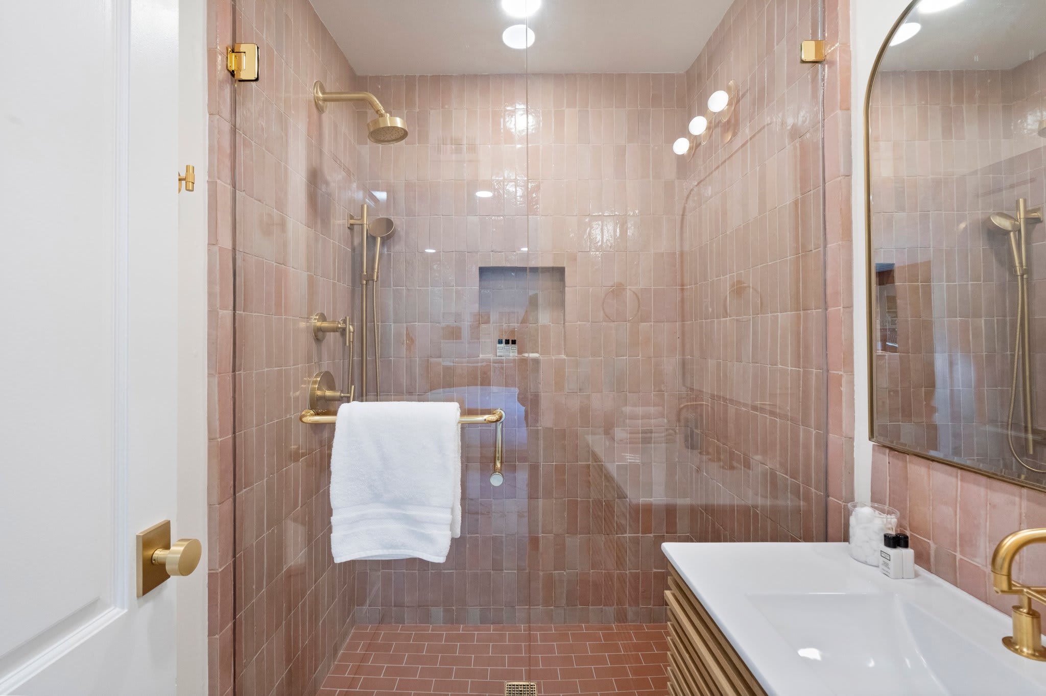 A shower that wraps you in rich texture and soft, rosy hues.