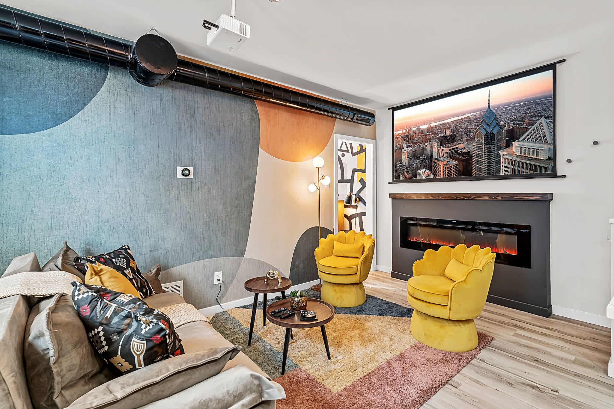 Unwind in this vibrant living room! The projector, fireplace, and fun decor make it the perfect place to relax after exploring Philly.