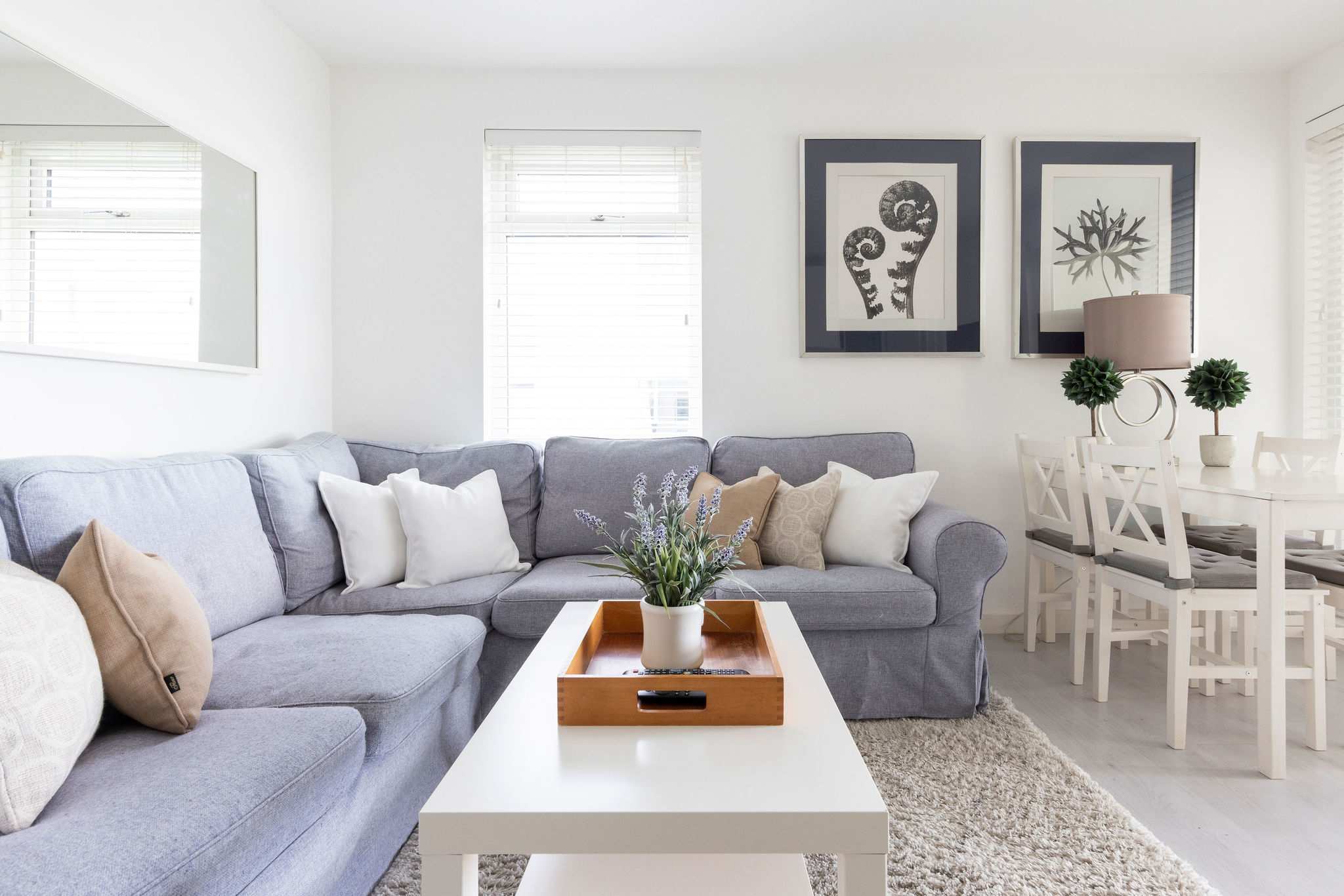 A spacious L-shaped sofa is accompanied with plush, comfortable cushions.