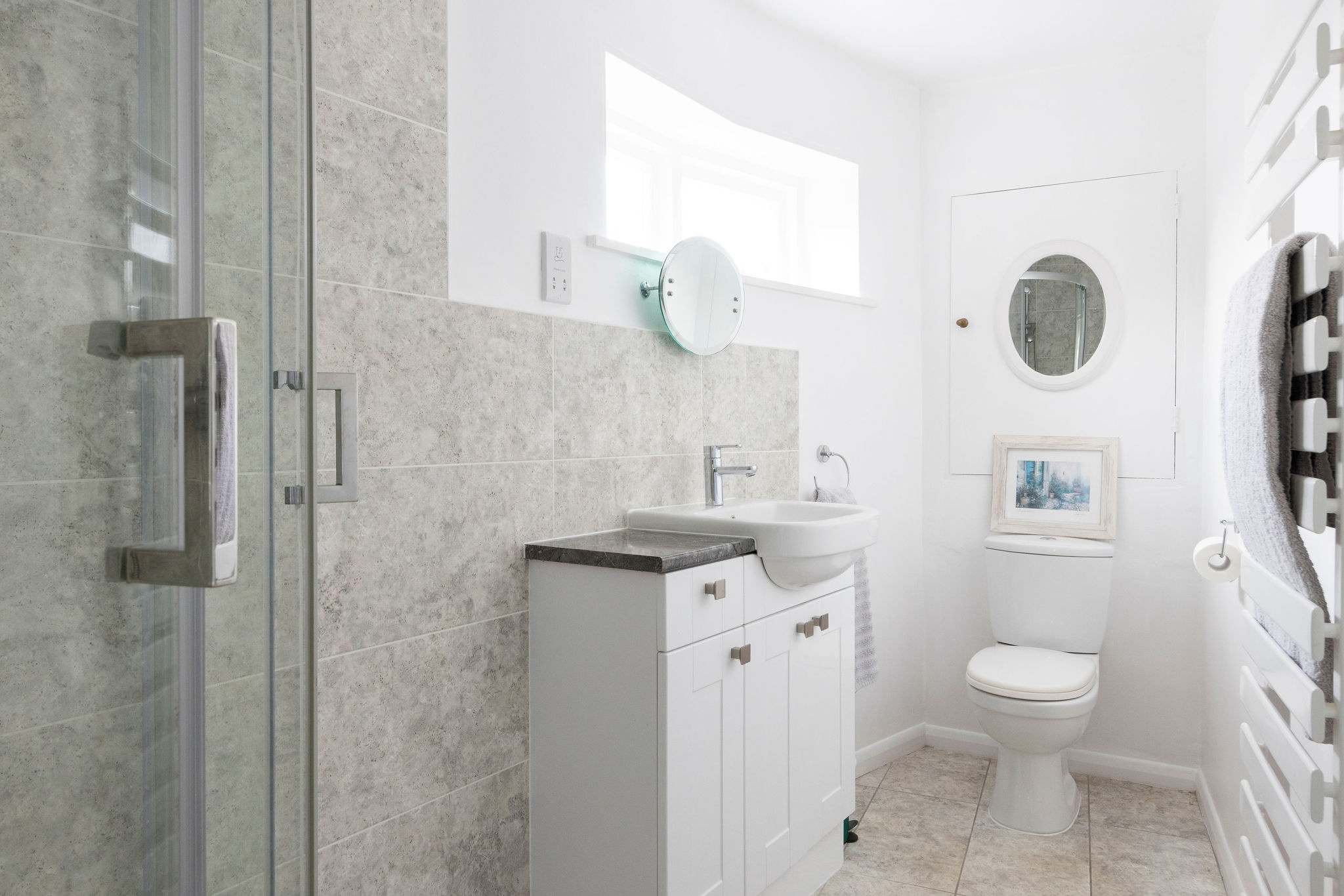 A bright bathroom with a walk-in shower and stylish tiling