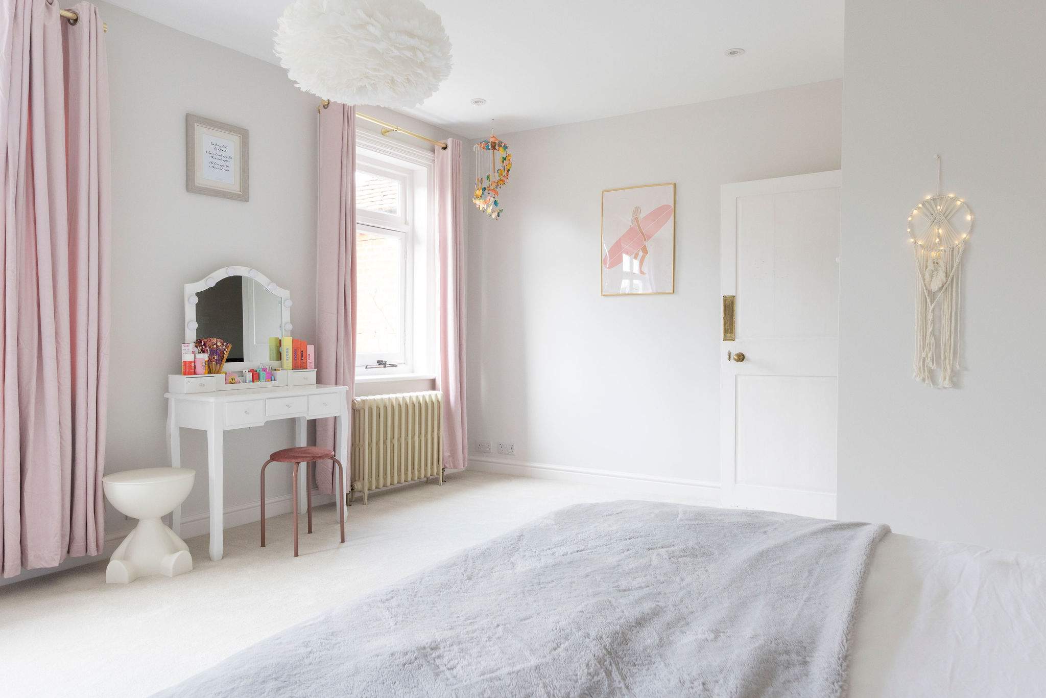 A beautifully styled bedroom with soft pastels and cosy décor