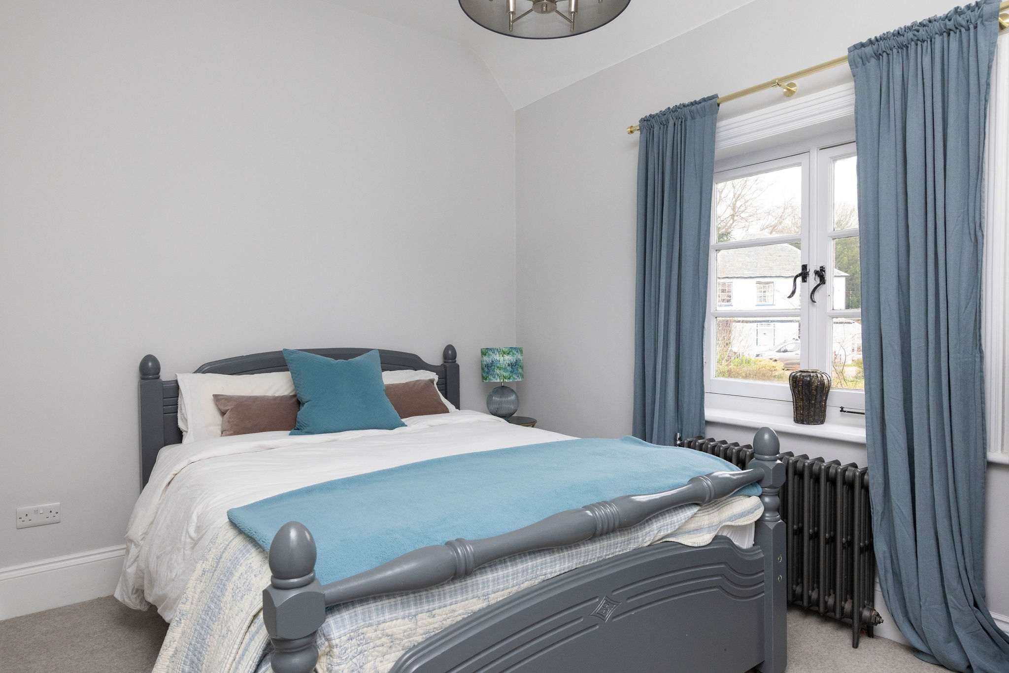 A cosy king bedroom with rich blue tones and soft textures