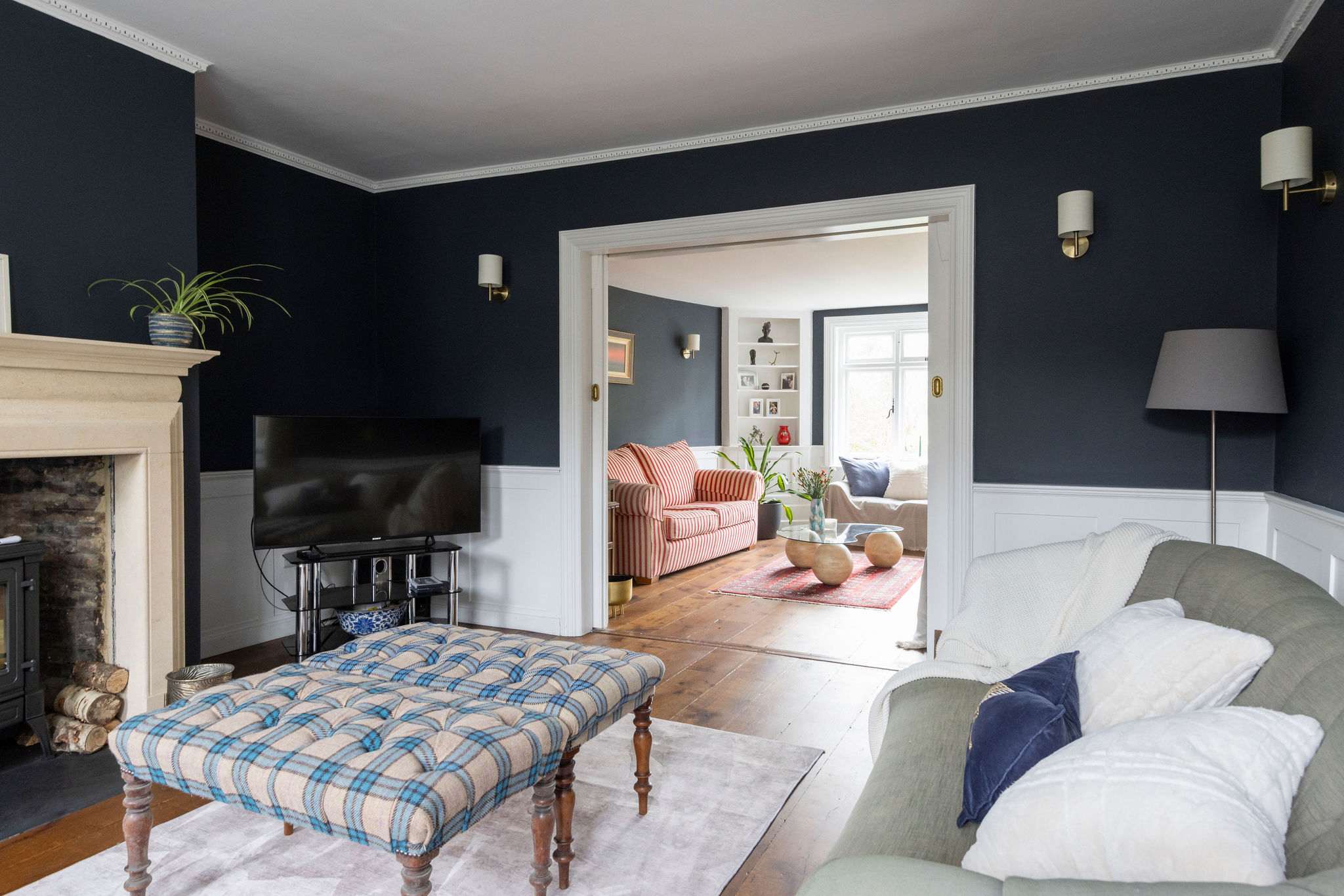 A cozy living room with deep tones and a wood-burning fireplace