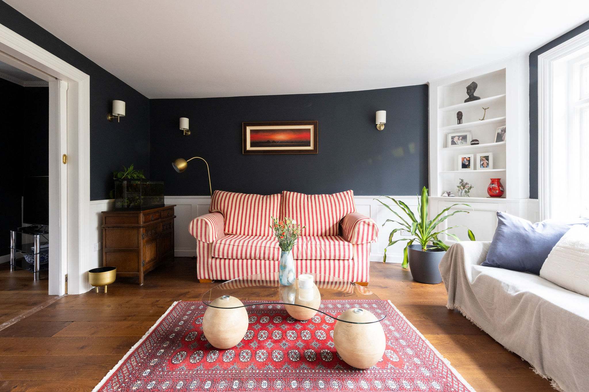 A cosy sitting area with a striped sofa, warm lighting, and elegant decor