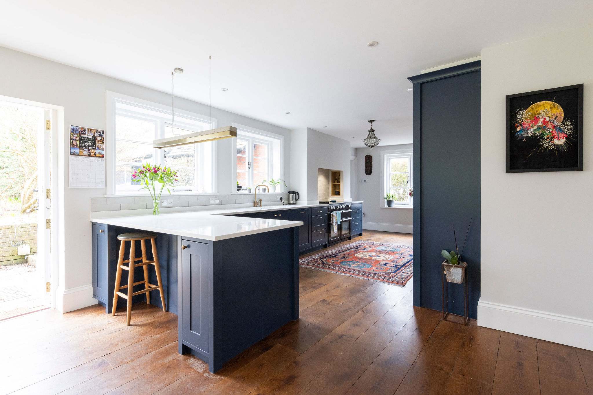 A modern kitchen with navy cabinetry, sleek finishes, and a central island