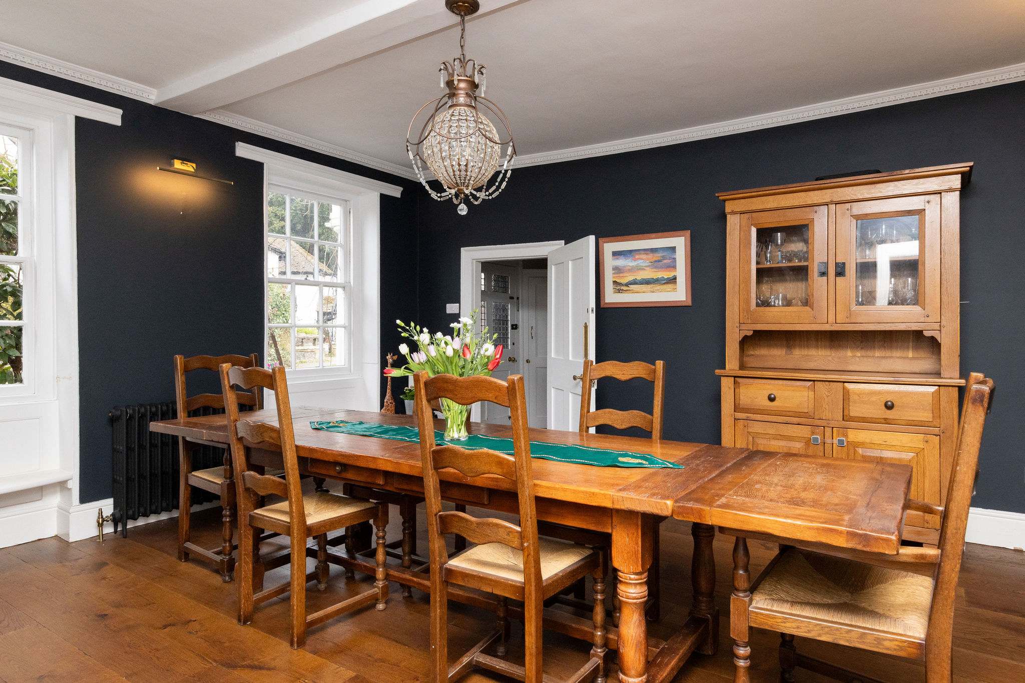 A traditional dining room with wooden furniture and elegant dark walls
