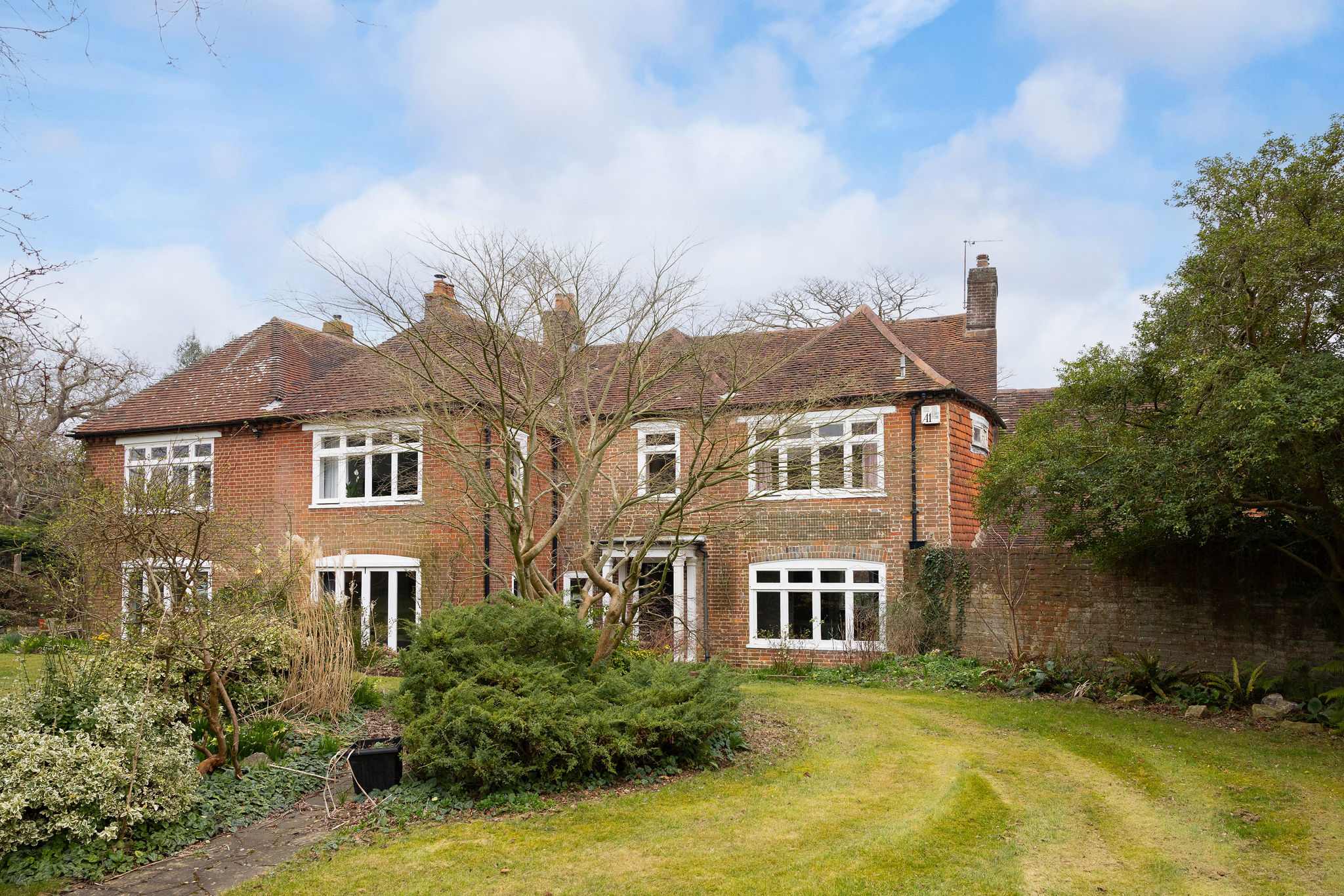 The rear garden features a spacious lawn and a classic period facade
